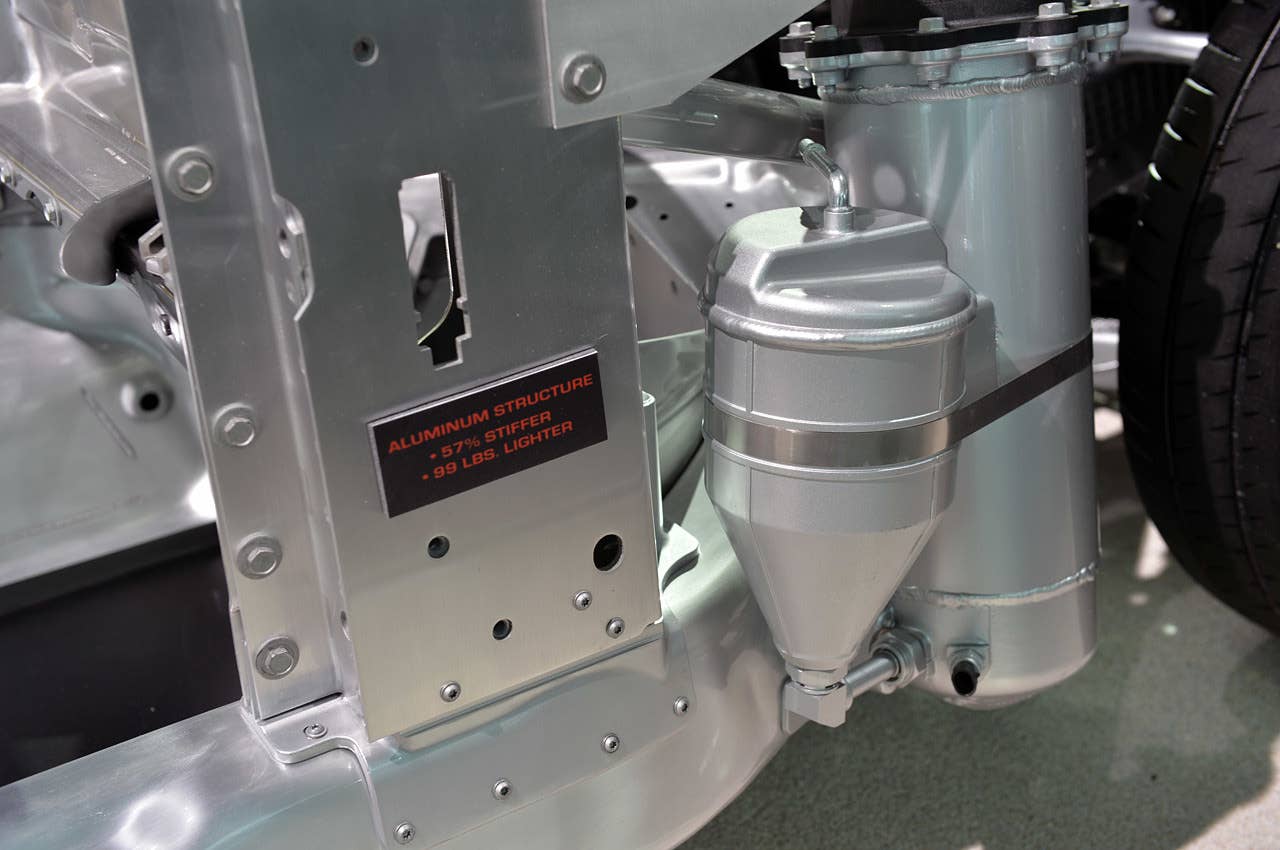 Hidden inside the right-front quarter panel, on the outside of the frame rail and behind the right front wheel, is the oil reservoir for the dry sump lubrication system. Open the hood, and you can see the yellow dipstick mounted on its lid.