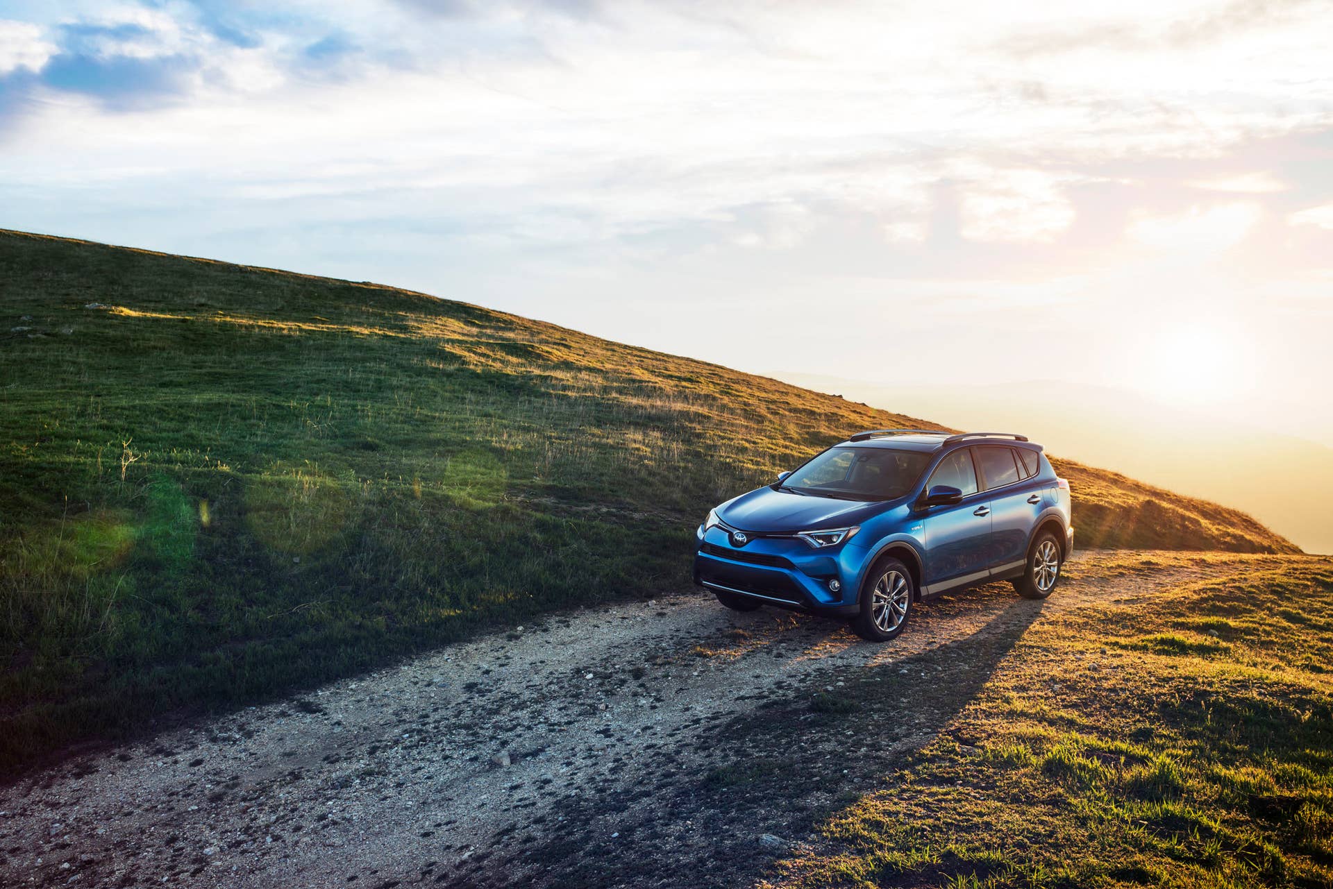 blue 2016 toyota rav4 hybrid gravel road
