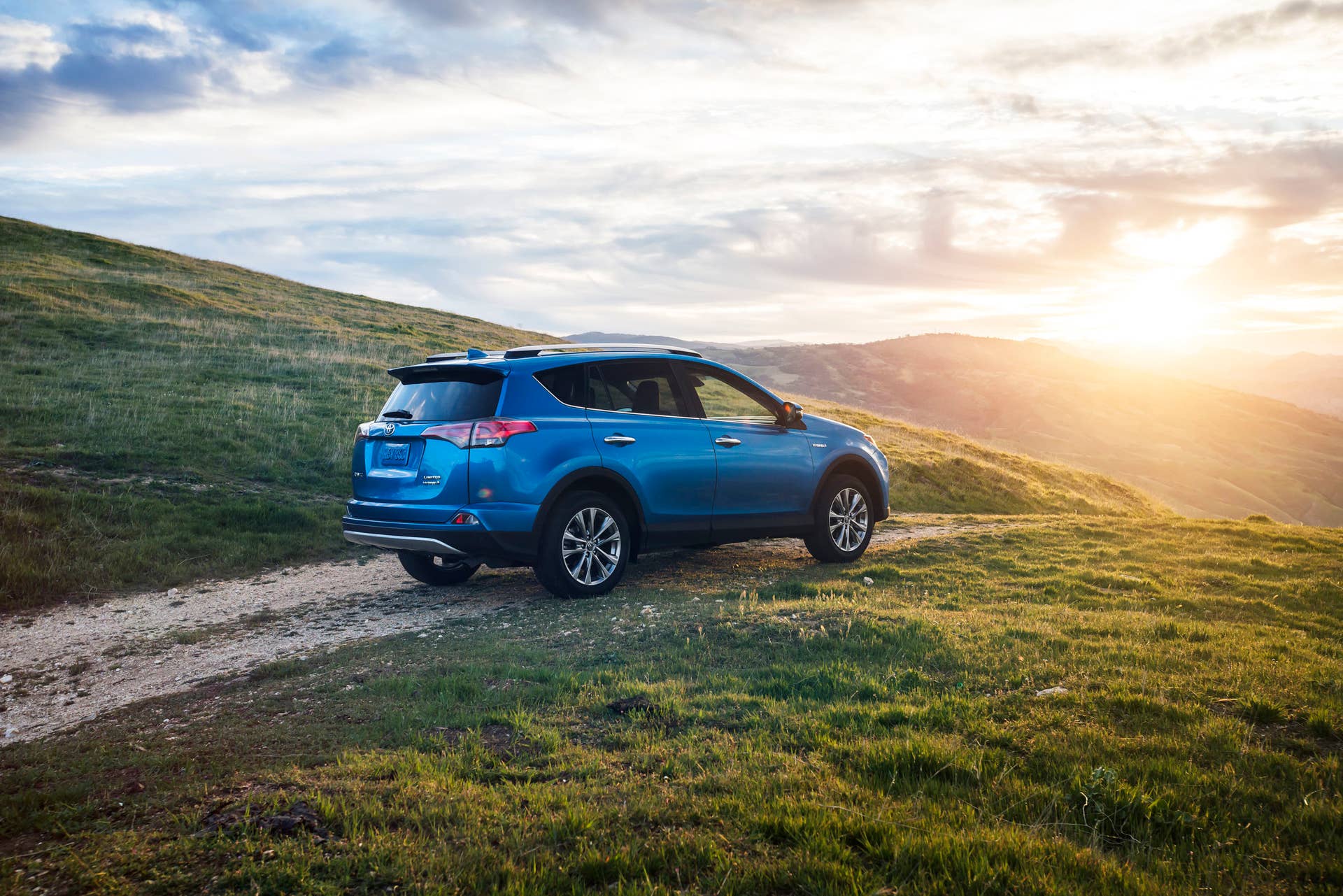 blue 2016 toyota rav4 hybrid rear gravel road