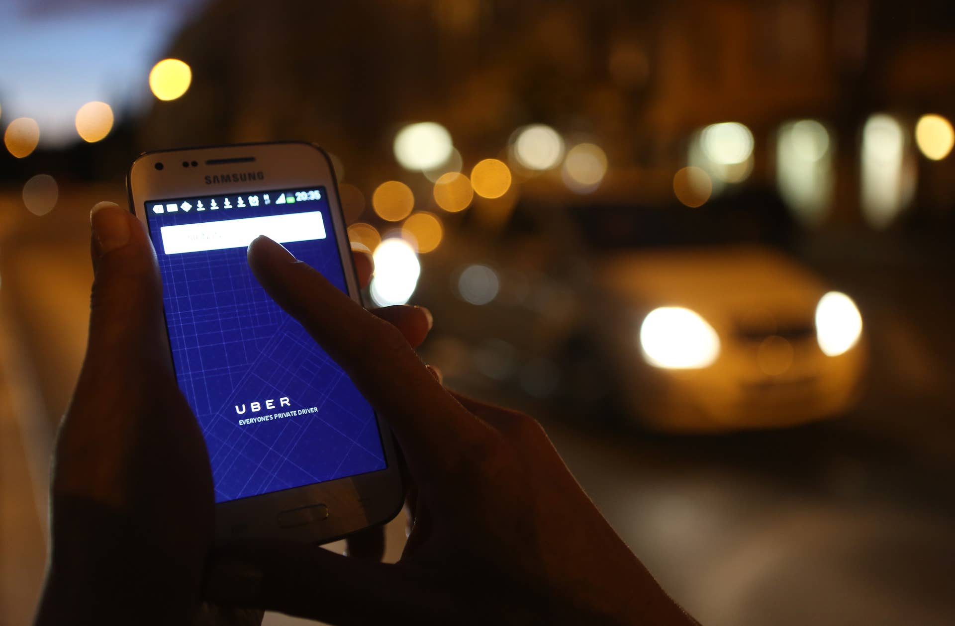 BERLIN, GERMANY - SEPTEMBER 02:  In this photo illustration, a woman uses the Uber app on an Samsung smartphone on September 2, 2014 in Berlin, Germany. Uber, an app that allows passenger to buy rides from drivers who do not have taxi permits, has had its UberPop freelance driver service banned in Germany after a complaint by Taxi Deutschland, a trade association of taxi drivers in the country. The company, which operates in 42 countries over 200 cities worldwide, plans to both appeal the decision made by a court in Frankfurt as well as, at the risk of heavy fines, continue its services in Germany until a final decision has been made on the matter.  (Photo by Adam Berry/Getty Images)