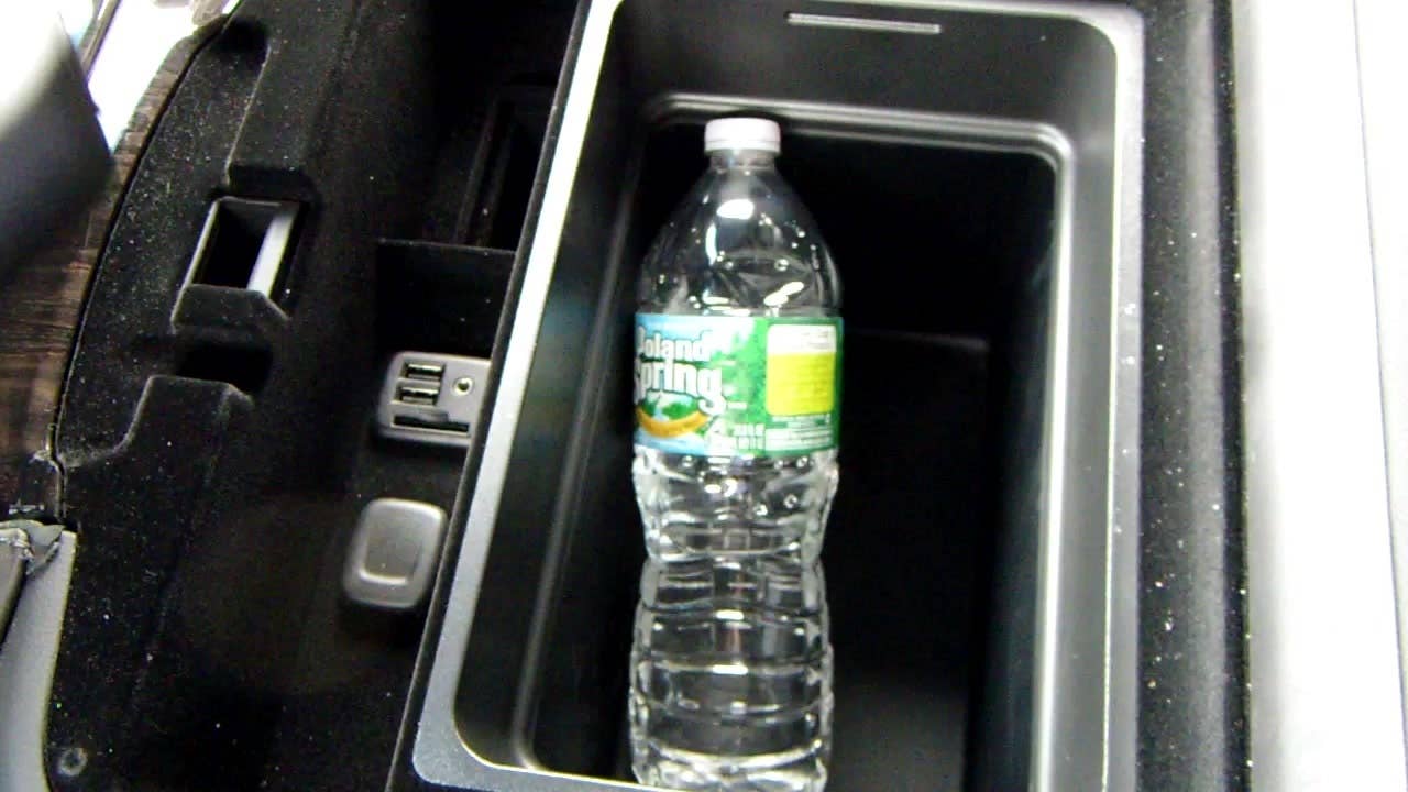 Autoblog's Jeremy Korzeniewski demonstrates the center console-mounted refrigerator in the 2015 Cadillac Escalade Platinum.