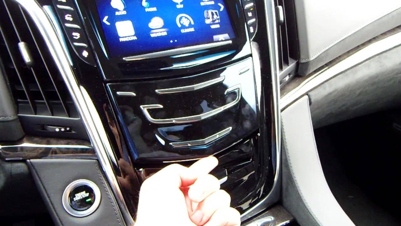 Autoblog's Jeremy Korzeniewski demonstrates the hidden storage compartment in the 2015 Cadillac Escalade Platinum.