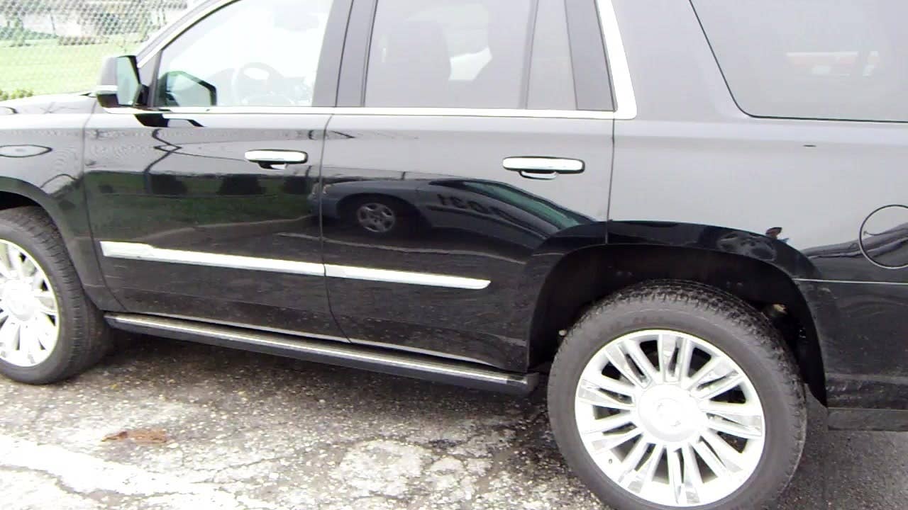 Autoblog's Jeremy Korzeniewski demonstrates the automatic side steps of the 2015 Cadillac Escalade Platinum.