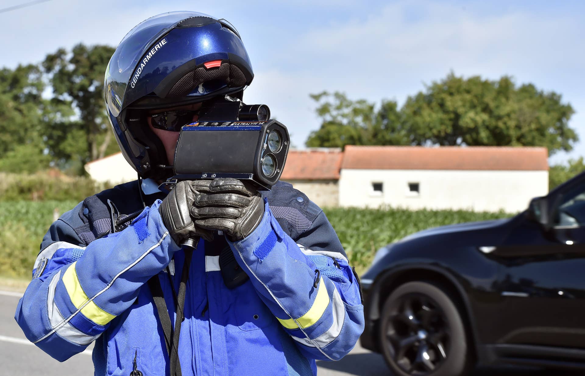 A policeman with a laser radar controls cars' speed during a roadside check near Nantes on June 26, 2015. Speed control operations will increase in France ahead of the holiday departures. AFP PHOTO / GEORGES GOBET (Photo credit should read GEORGES GOBET/AFP/Getty Images)