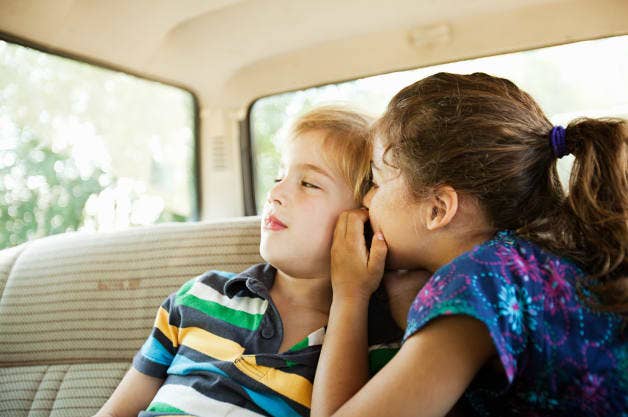 Girl whispering to boy
