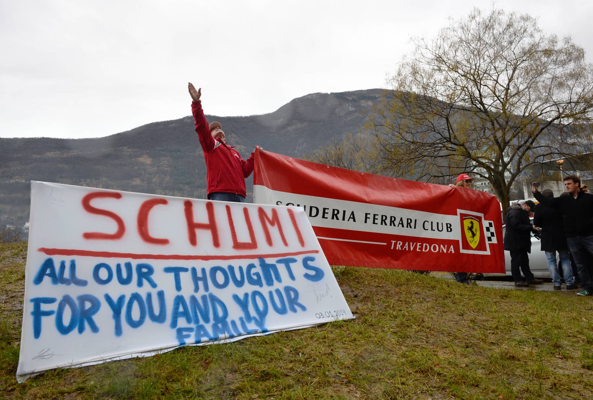 Fans of German Formula One world champion Michael Schumacher put a sign with messages of support and a banner of F1 Ferrari team, on January 3, 2014, in front of the Grenoble University Hospital Centre, to mark the 45th birthday of the former pilot. Formula One legend is to turn 45 today while lying comatose in a French hospital after suffering critical head injuries in a ski accident. AFP PHOTO/PHILIPPE DESMAZES (Photo credit should read PHILIPPE DESMAZES/AFP/Getty Images)