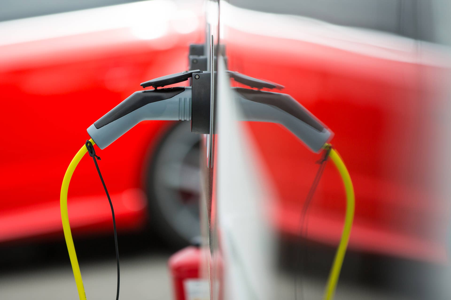 A charger for electric and hybrid automobiles sits at a charging station outside the Volkswagen AG (VW) factory in Wolfsburg, Germany, on Friday, May 20, 2016. Volkswagen AG agreed to raise German workers' pay after labor leaders vowed that employees wont foot the multi-billion-euro bill to resolve its diesel-emissions scandal. Photographer: Krisztian Bocsi/Bloomberg via Getty Images