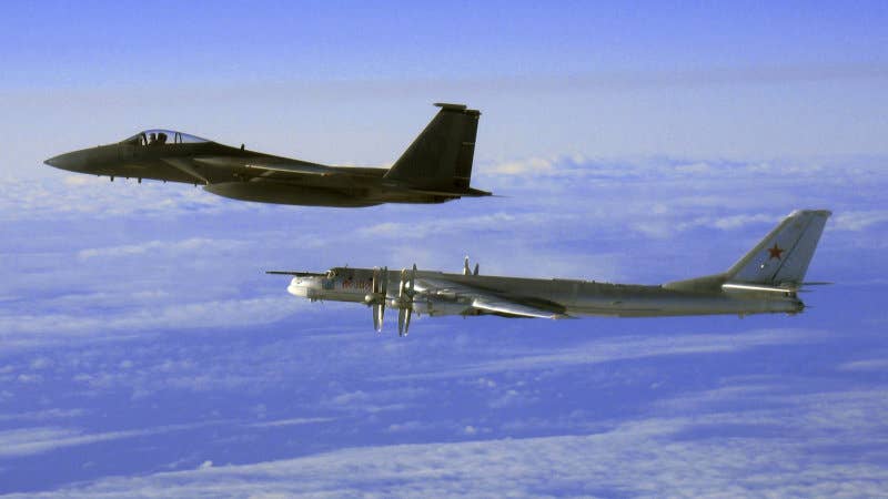 In this U.S. Navy handout, a F/A-18 Hornet strike fighter intercepts one of two Russian Tu-95 Bear long rang bomber aircraft as it approached the U.S. Navy aircraft carrier USS Nimitz February 9, 2008 south of Japan. Fighter planes escorted the bomber out of the area. Nimitz was transiting through the Western Pacific on a regularly scheduled deployment when the incident occurred. (Photo by U.S. Navy via Getty Images)