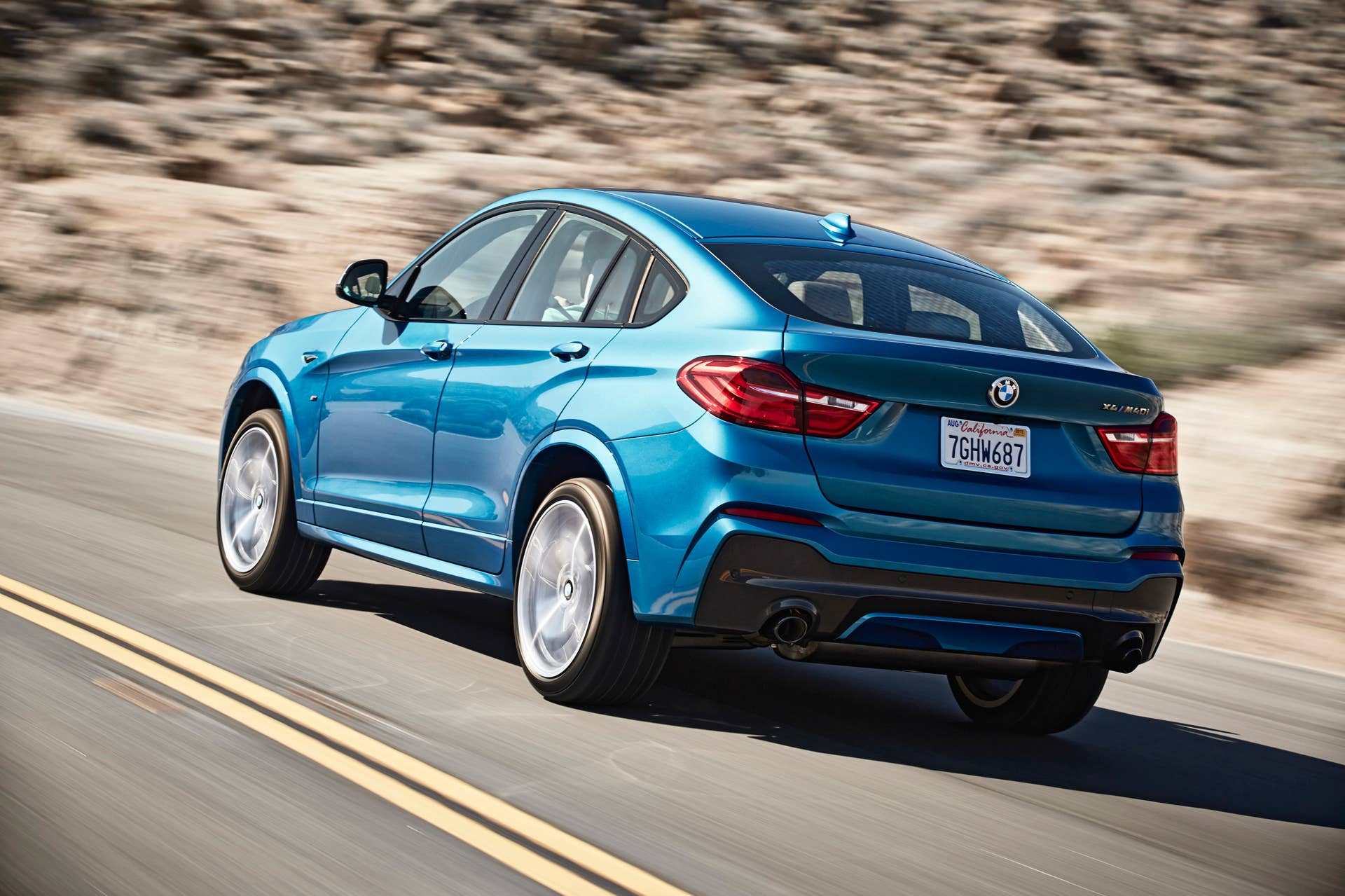 BMW X4 M40i rear 3/4 view driving