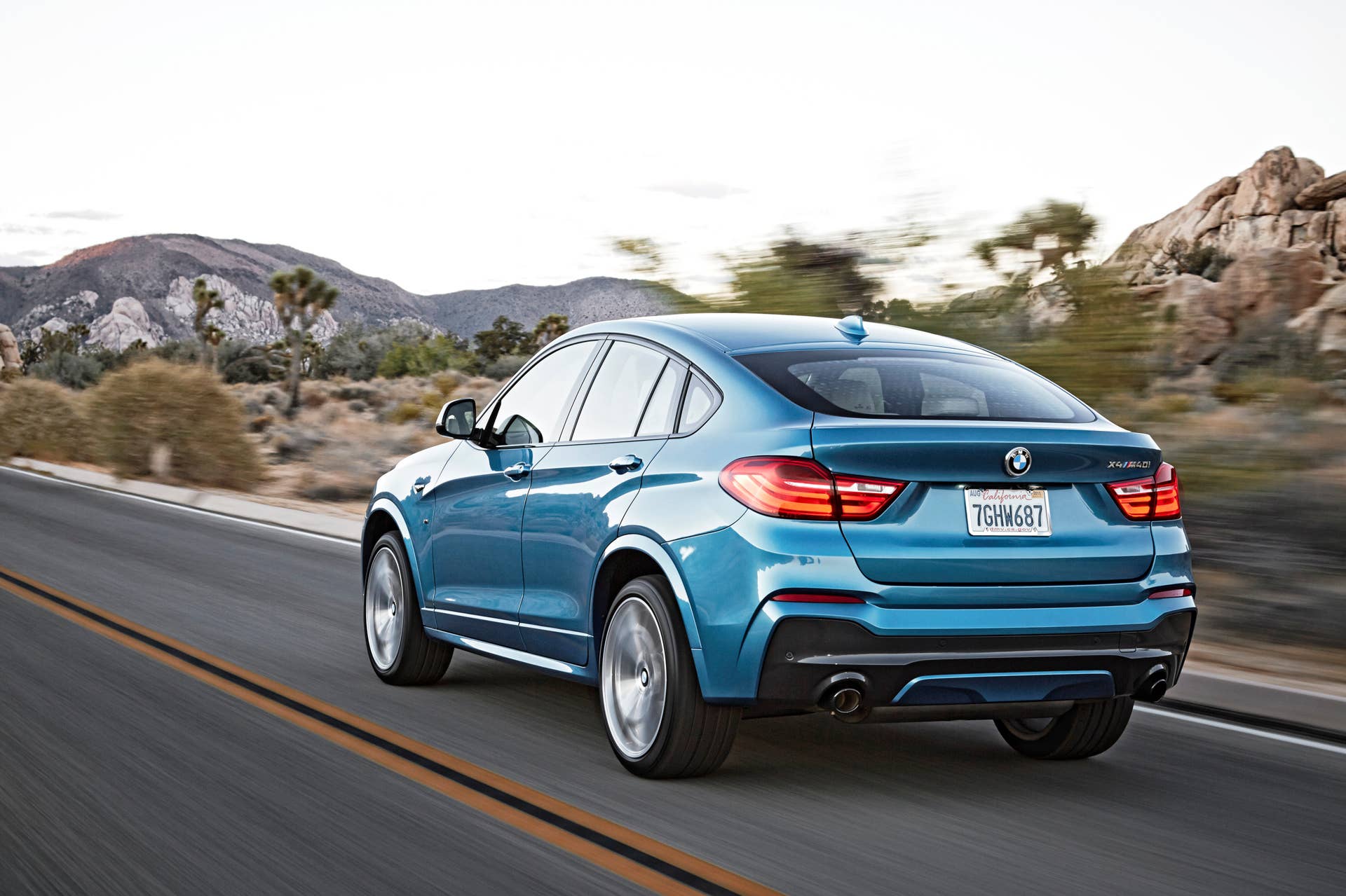 BMW X4 M40i rear 3/4 view blue rolling