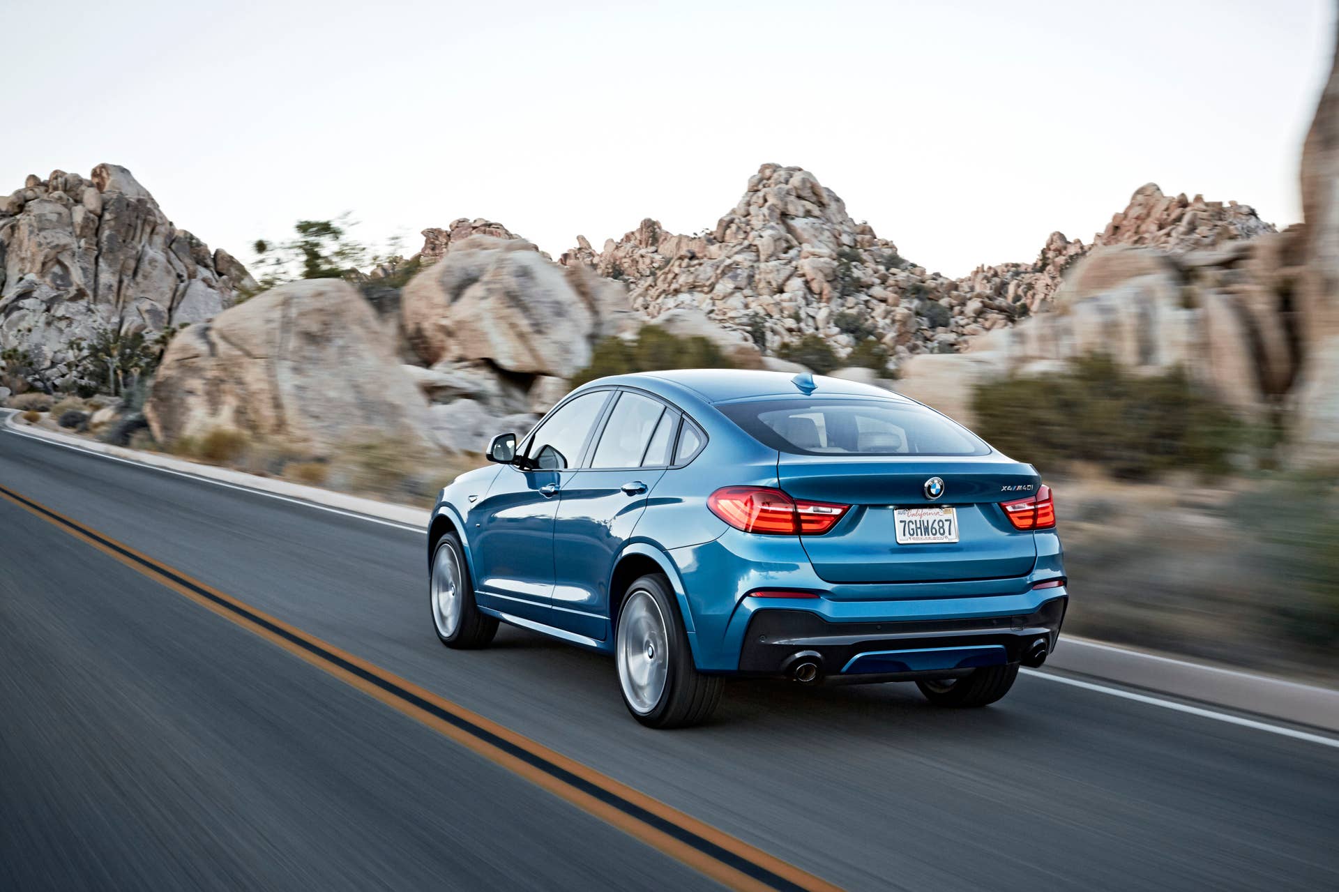 BMW X4 M40i rear 3/4 view blue road