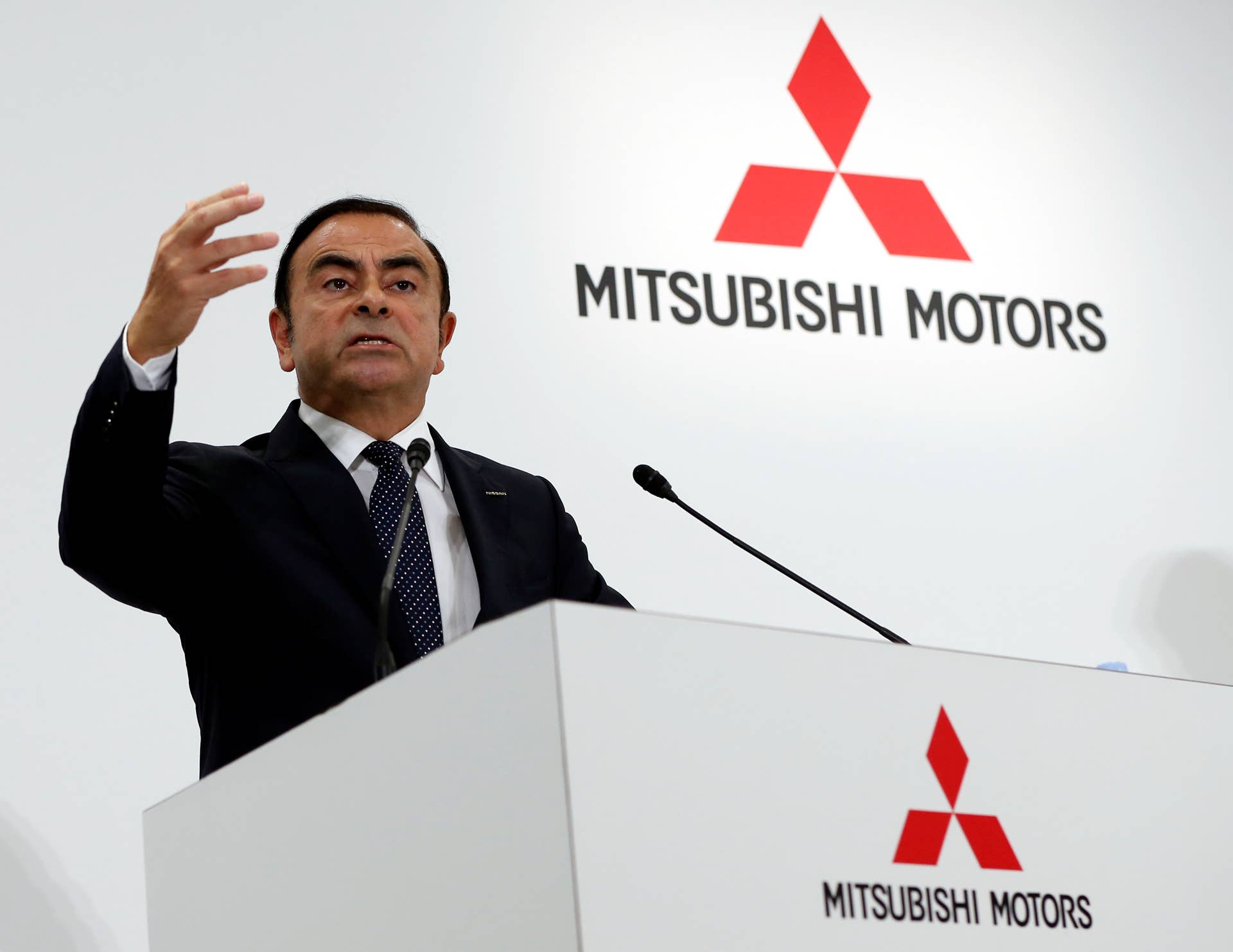 Carlos Ghosn, chairman and chief executive officer of Renault SA and Nissan Motor Co., left, shakes hands with Osamu Masuko, chairman and chief executive officer of Mitsubishi Motors Corp., as they pose for a picture a during a news conference in Tokyo, Japan, on Thursday, Oct. 20, 2016. Nissan completed its acquisition of a $2.3 billion stake in Mitsubishi Motors, clearing the way for Ghosn to take over as chairman of a scandal-plagued partner and embark on his bid to turn around a third major automaker. Photographer: Yuya Shino/Bloomberg via Getty Images