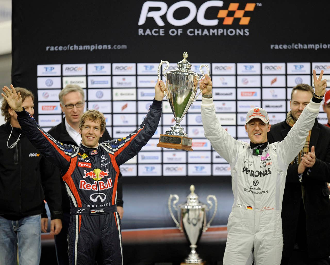 Germany's F1 drivers Sebastian Vettel, left, and partner Michael Schumacher celebrate after winning the the Race of Champions Nations Cup at the arena in Duesseldorf, western Germany, Saturday, Dec. 3, 2011.(AP Photo/Martin Meissner)