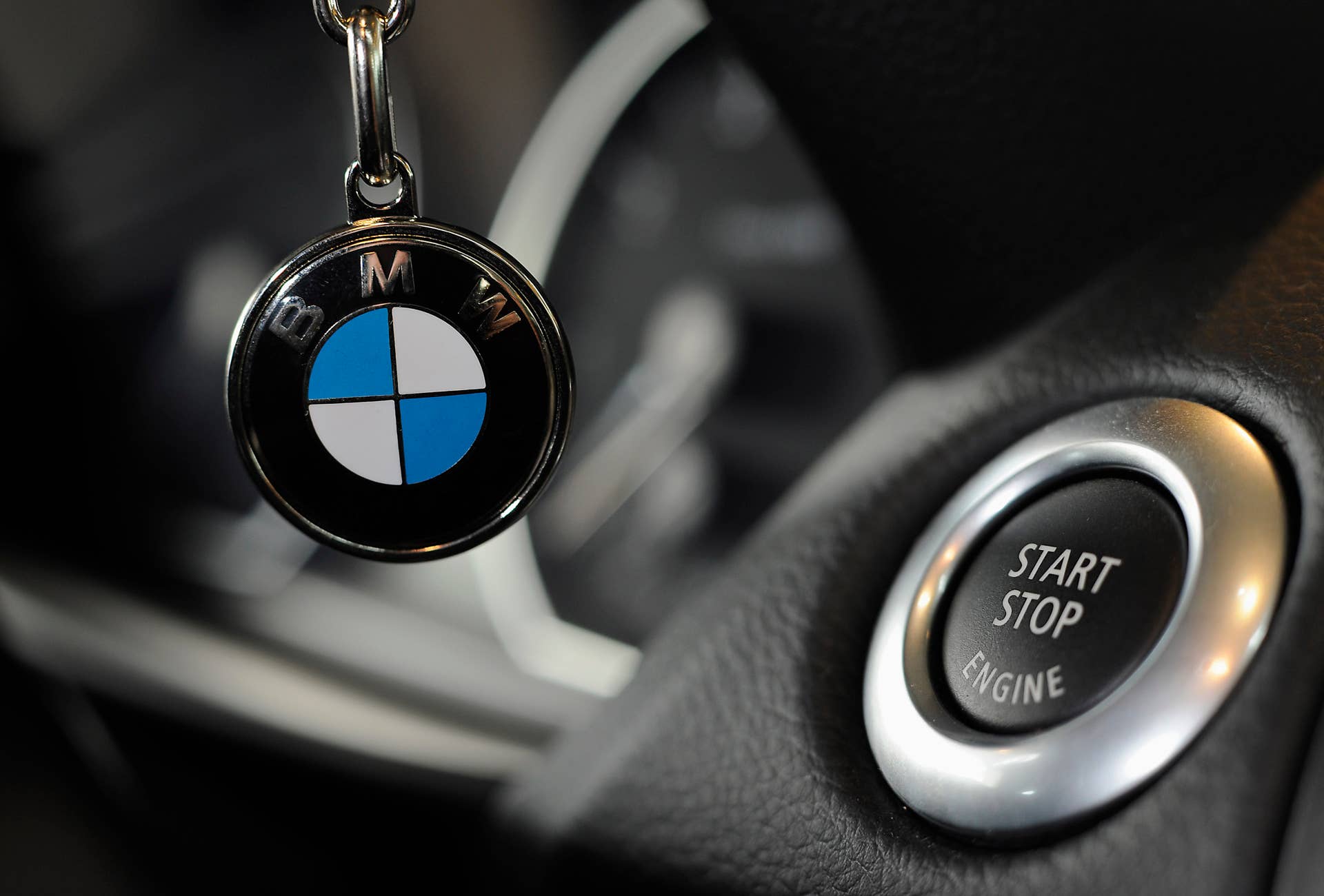 A Bayerische Motoren Werke (BMW) logo is seen on a key ring next to a car's ignition start button at a dealership in Rosenheim, Germany, on Tuesday, May 18, 2010. Bayerische Motoren Werke AG, the world's largest maker of luxury vehicles, said orders for the revamped 5-Series have 'considerably' exceeded the carmaker's own targets. Photographer: Guenter Schiffmann/Bloomberg via Getty Images