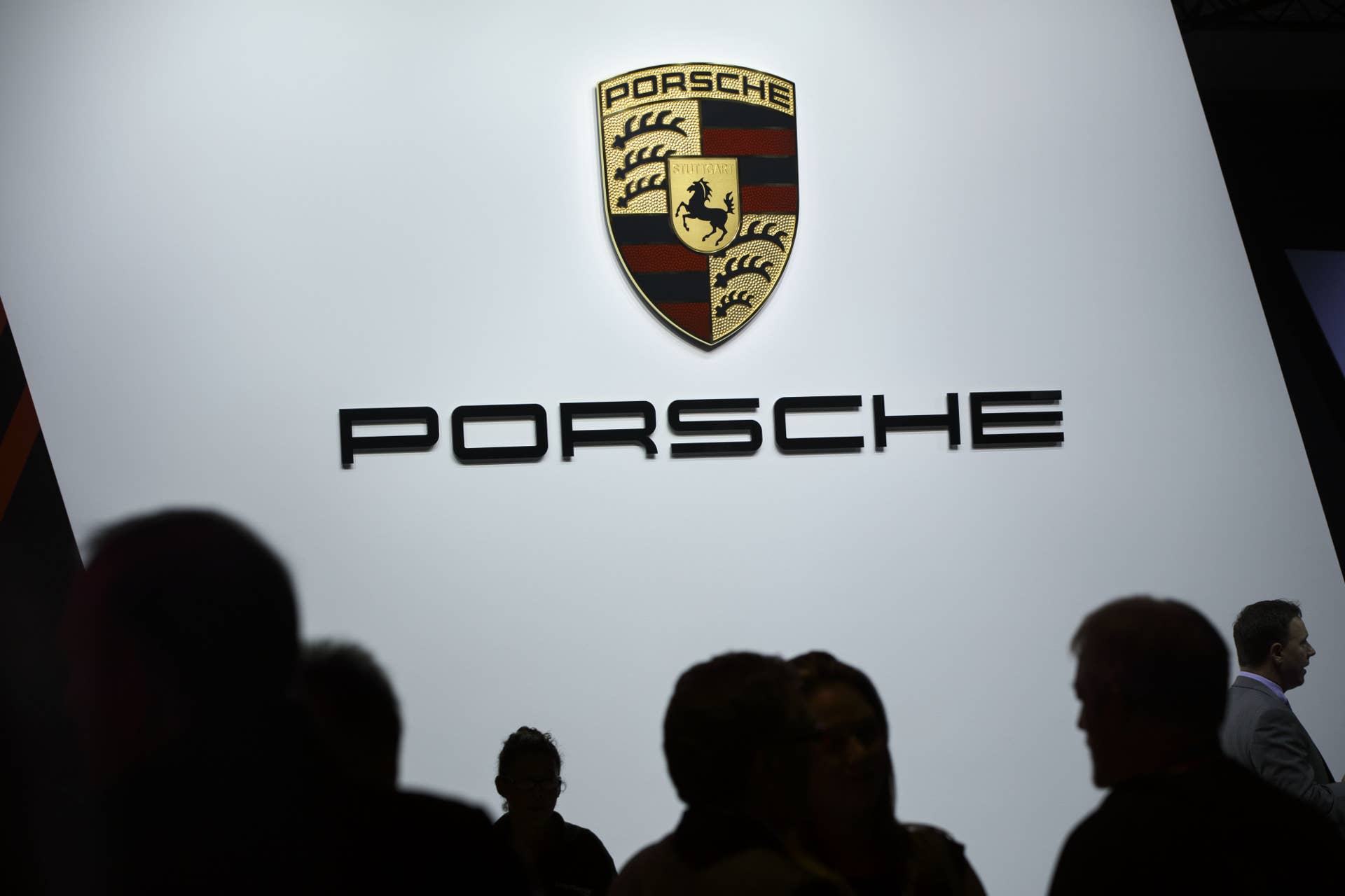 The silhouettes of attendees are seen under the Porsche Automobil Holding SE displayed during Automobility LA ahead of the Los Angeles Auto Show in Los Angeles, California, U.S., on Wednesday, November 16, 2016. The Connected Car Expo and LA Auto Show press days have merged to form AutoMobility LA. The show is open to the public November 18-27. Photographer: Patrick T. Fallon/Bloomberg via Getty Images