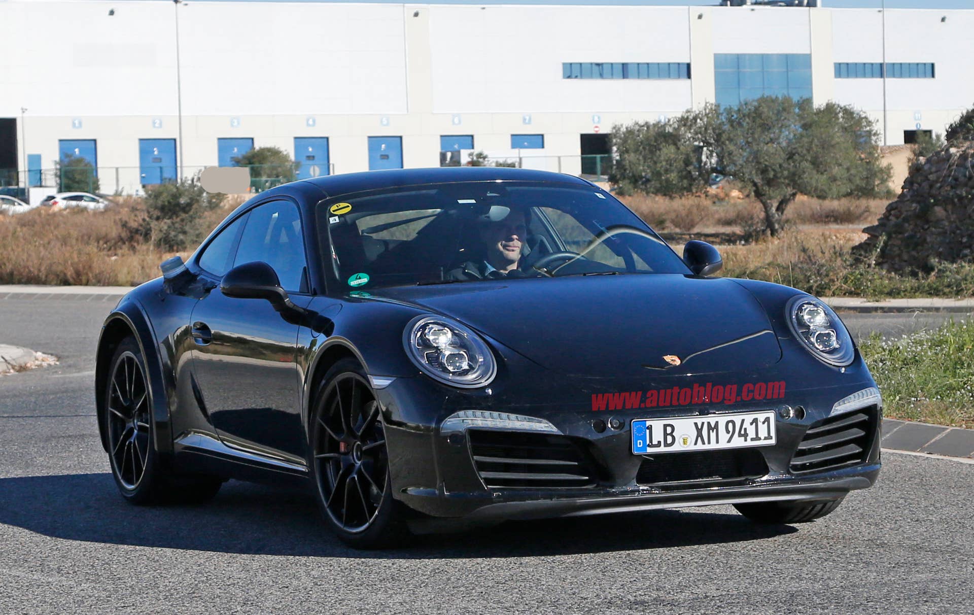 Spy shot of the next-generation 992-model Porsche 911 thought to hide a hybrid powertrain, front three-quarter.