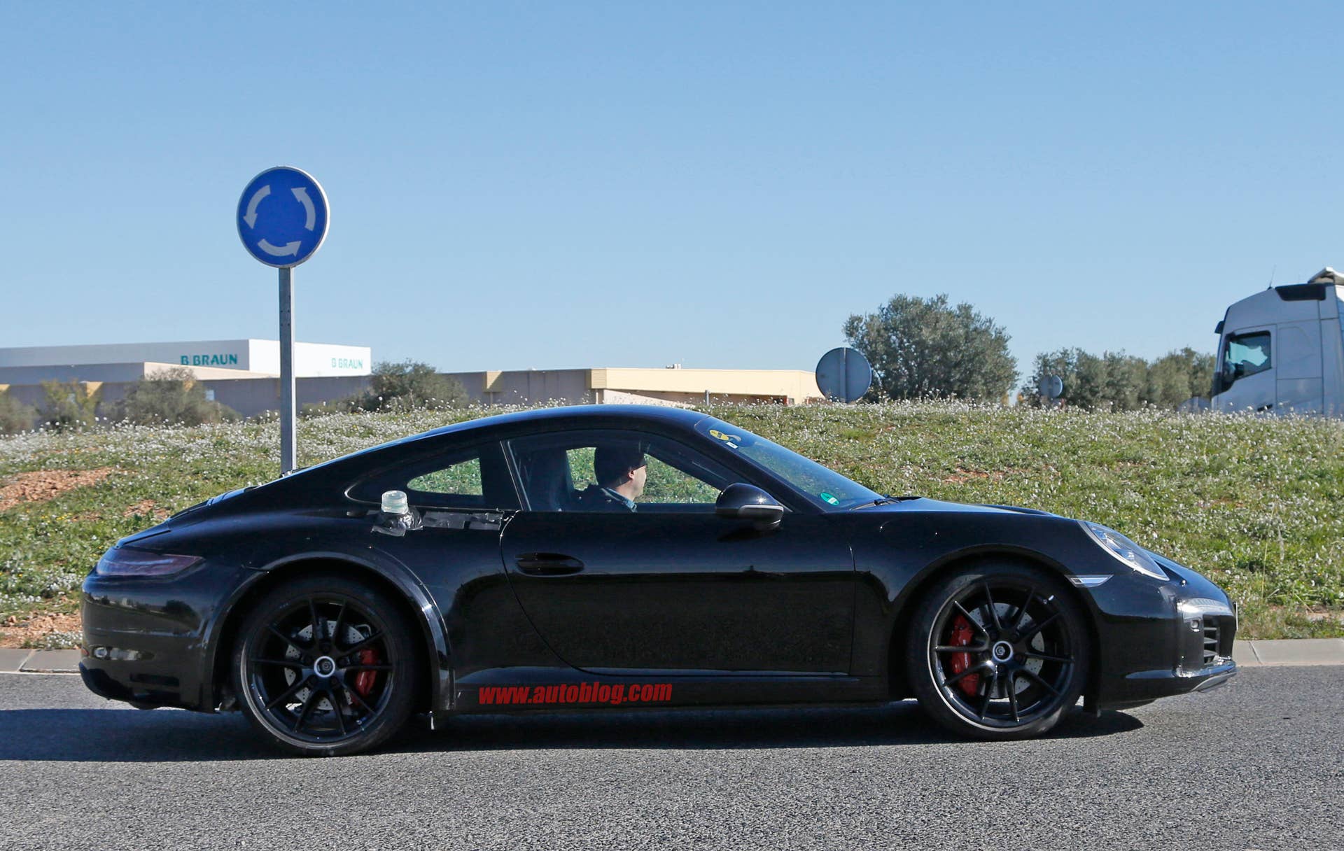 Spy shot of the next-generation 992-model Porsche 911 thought to hide a hybrid powertrain, side.