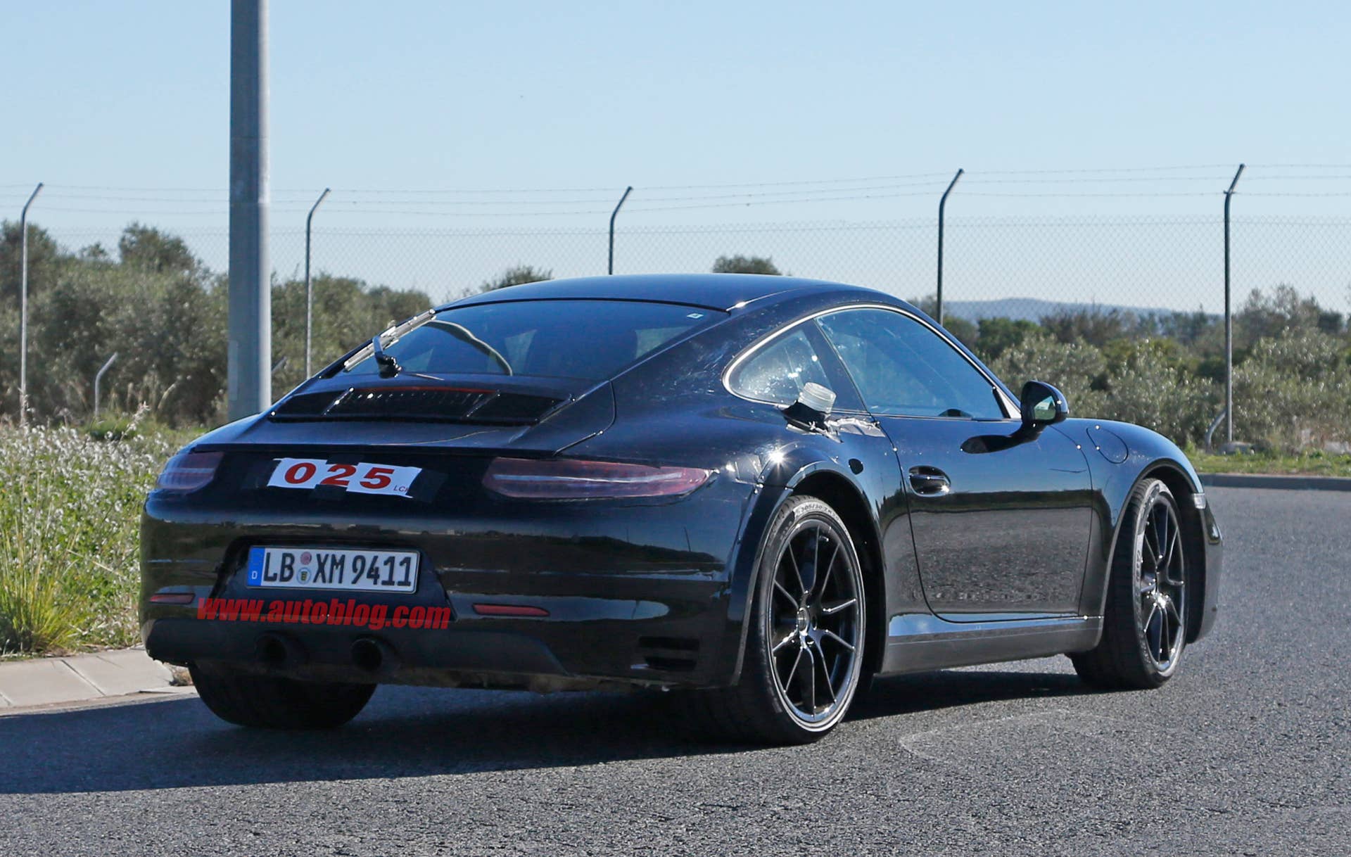 Spy shot of the next-generation 992-model Porsche 911 thought to hide a hybrid powertrain, rear three-quarter. The rear fender flares hide a wider rear axle.