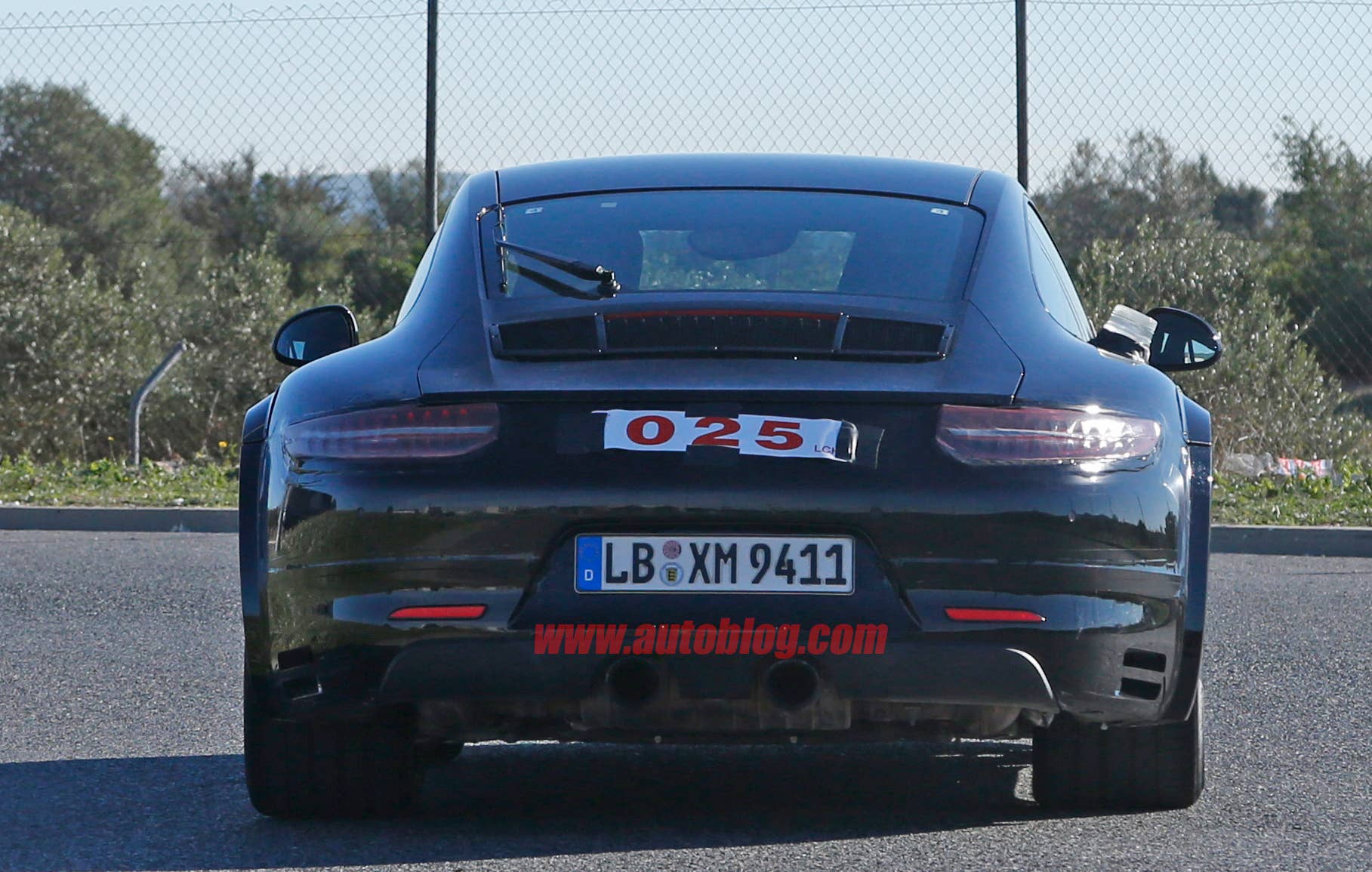Spy shot of the next-generation 992-model Porsche 911 thought to hide a hybrid powertrain, rear view.