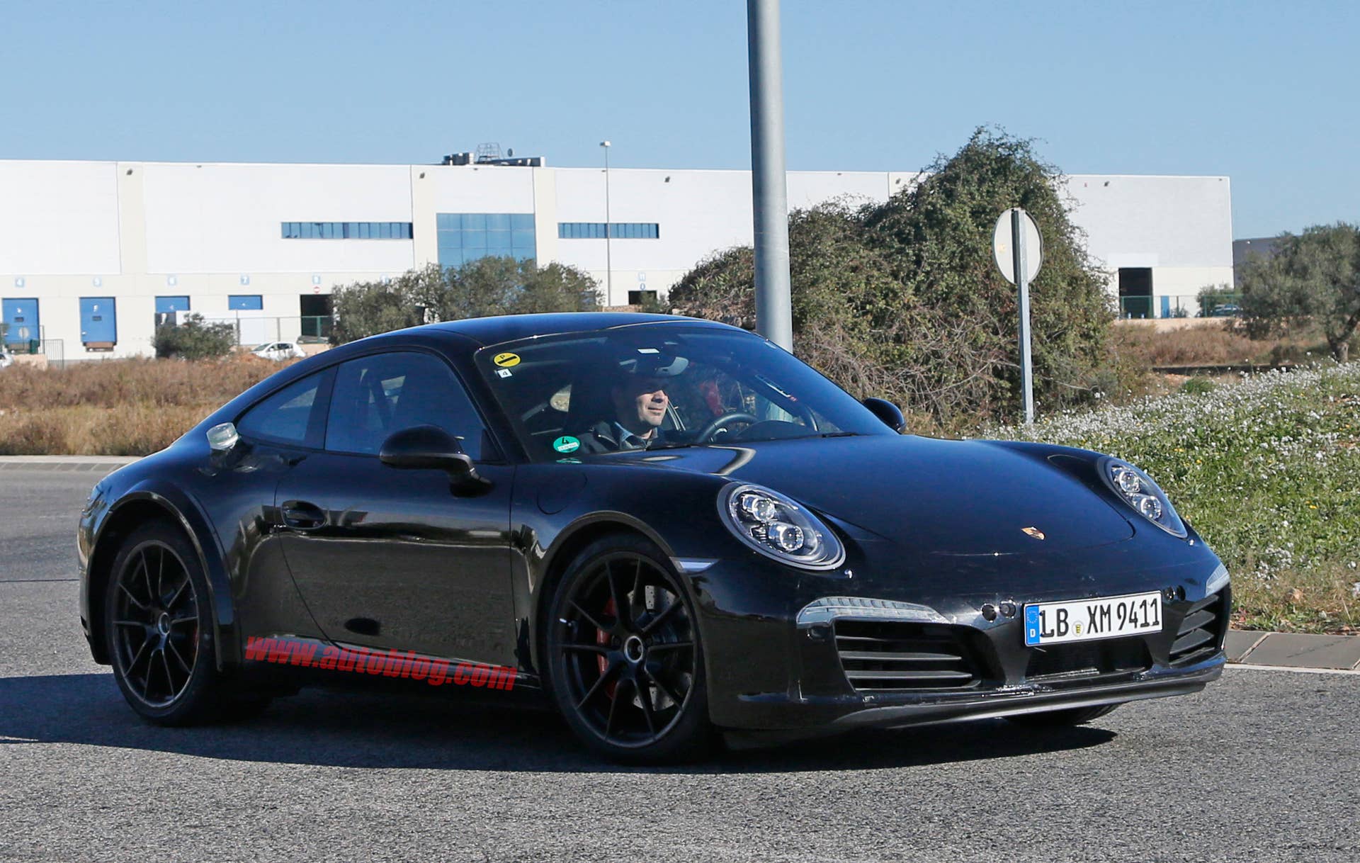 Spy shot of the next-generation 992-model Porsche 911 thought to hide a hybrid powertrain, front three-quarter.