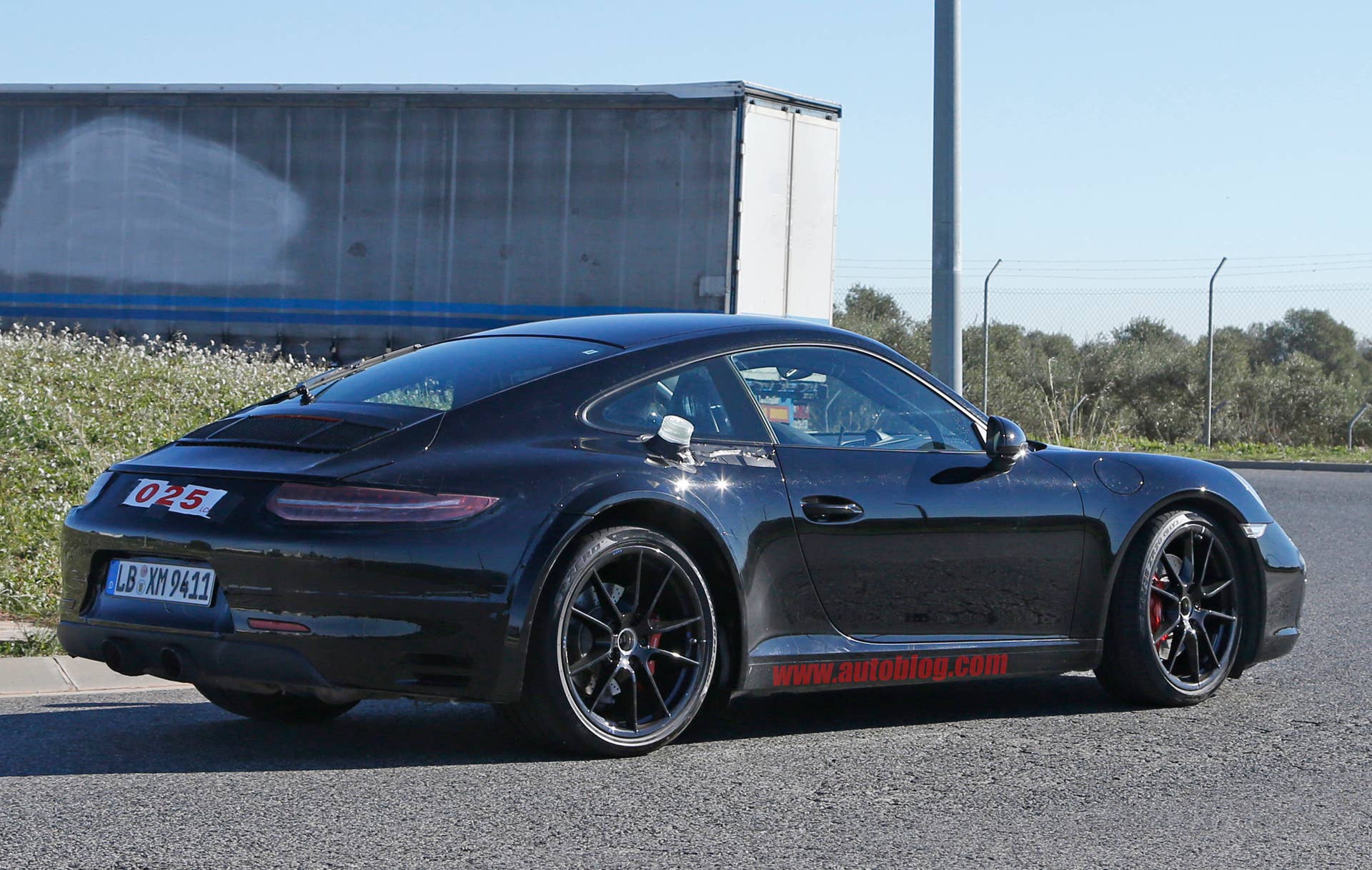Spy shot of the next-generation 992-model Porsche 911 thought to hide a hybrid powertrain, rear three-quarter.