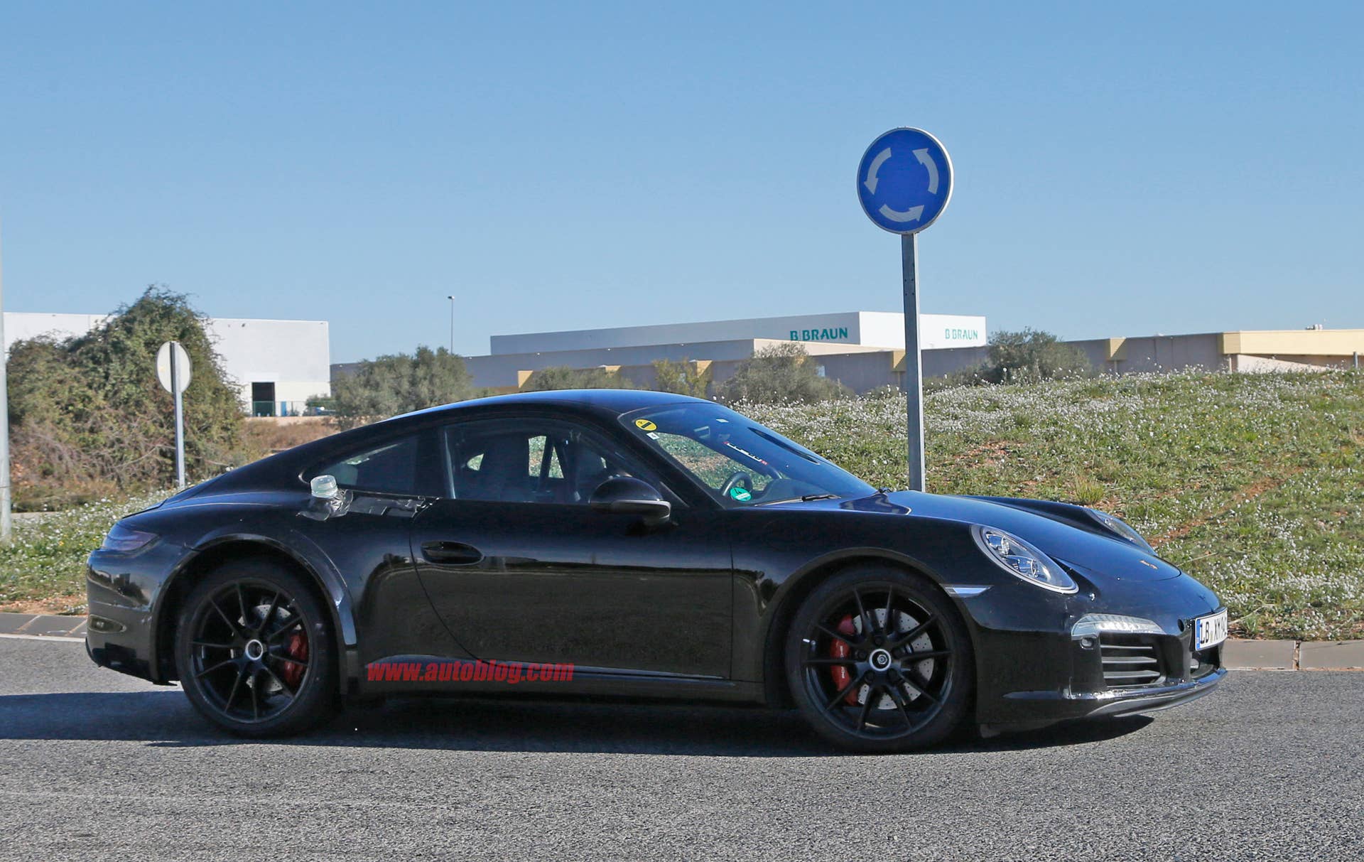 Spy shot of the next-generation 992-model Porsche 911 thought to hide a hybrid powertrain, side view.