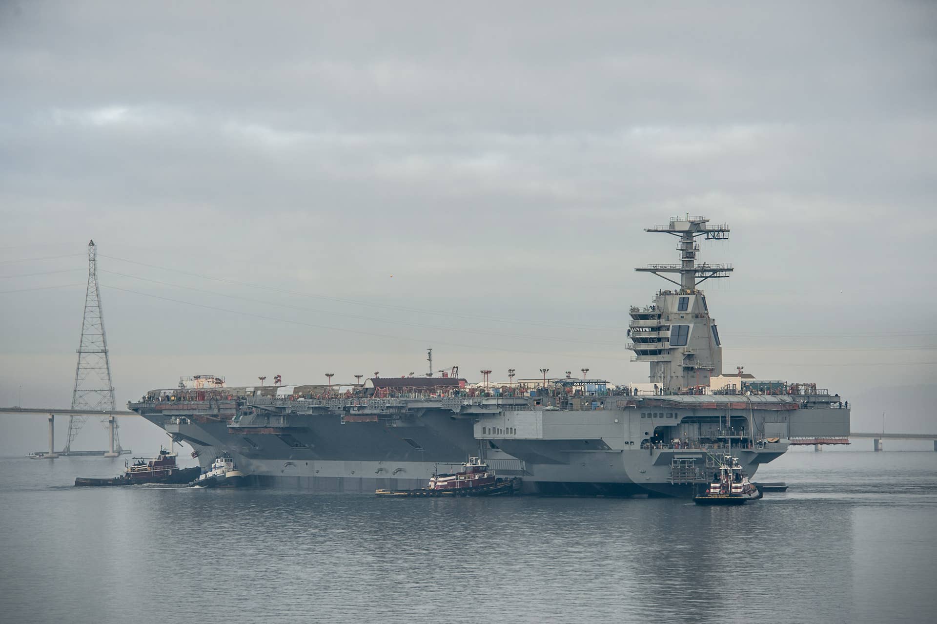 The aircraft carrier Pre-Commissioning Unit (PCU) Gerald R. Ford (CVN 78) is moved to Pier 3 at Newport News Shipbuilding. The ship will undergo additional outfitting and testing for the next 28 months. (U.S. Navy photo courtesy of Huntington Ingalls Industries by Chris Oxley/Released)