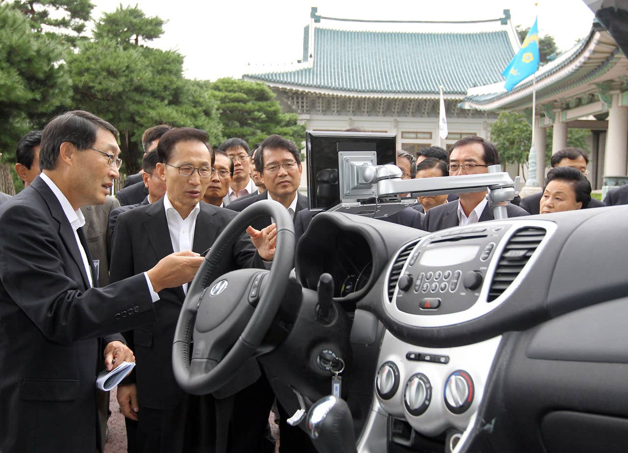 South Korean President Lee Myung-Bak (2nd L) listens to an introduction about Hyundai's first full-speed electric vehicle, BlueOn, during an unveiling ceremony at the presidential Blue House in Seoul on September 9m 2010. Hyundai Motor unveiled South Korea's first full-speed electric car, designed to tap into the increasingly competitive electric auto market, hailed as the industry's future. (Photo credit: DONG-A ILBO/AFP/Getty Images)