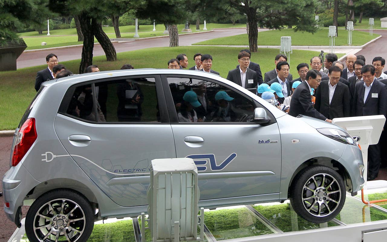 South Korean President Lee Myung-Bak (2nd R) listens to an introduction about Hyundai's first full-speed electric vehicle, BlueOn, during an unveiling ceremony at the presidential Blue House in Seoul on September 9m 2010. Hyundai Motor unveiled South Korea's first full-speed electric car, designed to tap into the increasingly competitive electric auto market, hailed as the industry's future. (Photo credit: DONG-A ILBO/AFP/Getty Images)