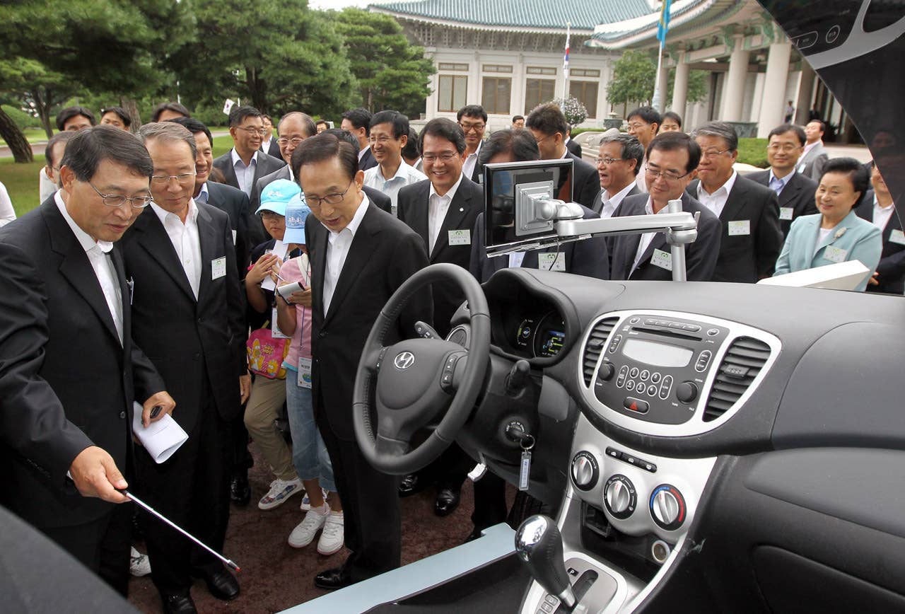 South Korean President Lee Myung-Bak (C) listens to an introduction about Hyundai's first full-speed electric vehicle, BlueOn, during an unveiling ceremony at the presidential Blue House in Seoul on September 9m 2010. Hyundai Motor unveiled South Korea's first full-speed electric car, designed to tap into the increasingly competitive electric auto market, hailed as the industry's future. (Photo credit: DONG-A ILBO/AFP/Getty Images)
