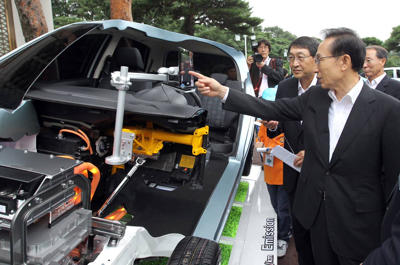 South Korean President Lee Myung-Bak (R) looks at Hyundai's first full-speed electric vehicle, BlueOn, during an unveiling ceremony at the presidential Blue House in Seoul on September 9m 2010. Hyundai Motor unveiled South Korea's first full-speed electric car, designed to tap into the increasingly competitive electric auto market, hailed as the industry's future. (Photo credit: DONG-A ILBO/AFP/Getty Images)