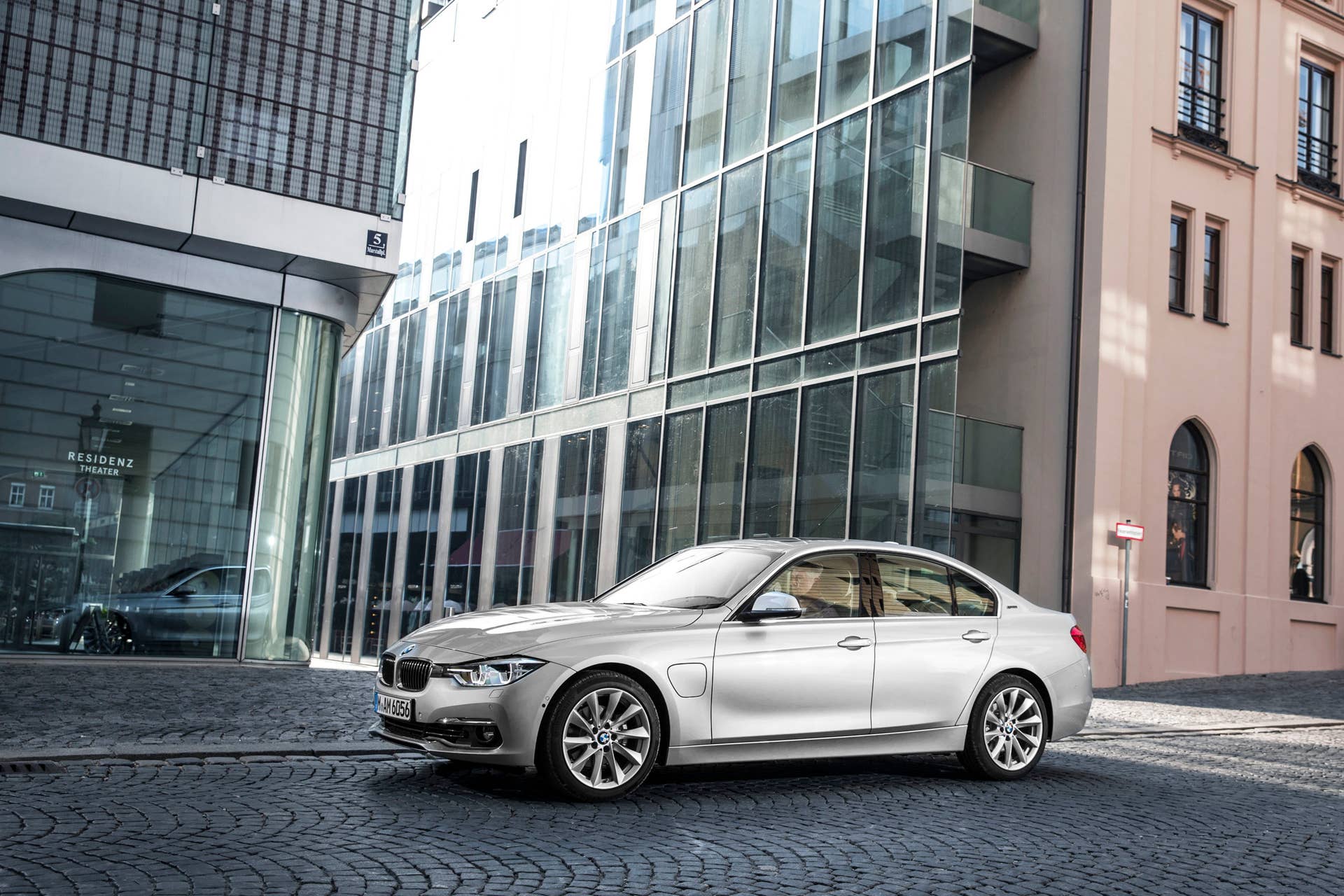bmw 330e driving by glass
