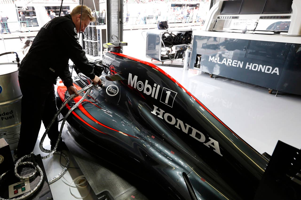 The car of Jenson Button is refuelled.