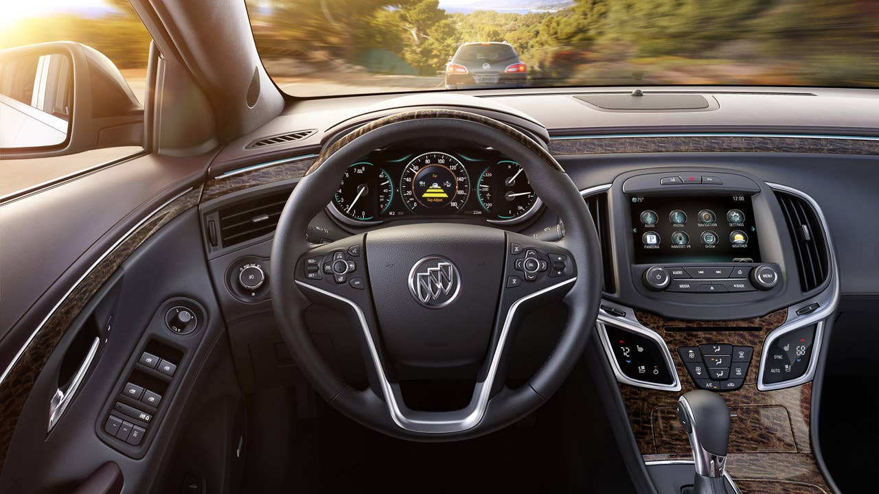 2014 Buick LaCrosse, Adaptive Cruise Control alert displayed in the 8-inch instrument panel (IP). This image also features next-generation IntelliLink infotainment system as well as the Light Neutral Soleil Keisel leather seating and Cocoa accents interior with Kyoto Maple wood-style decor.