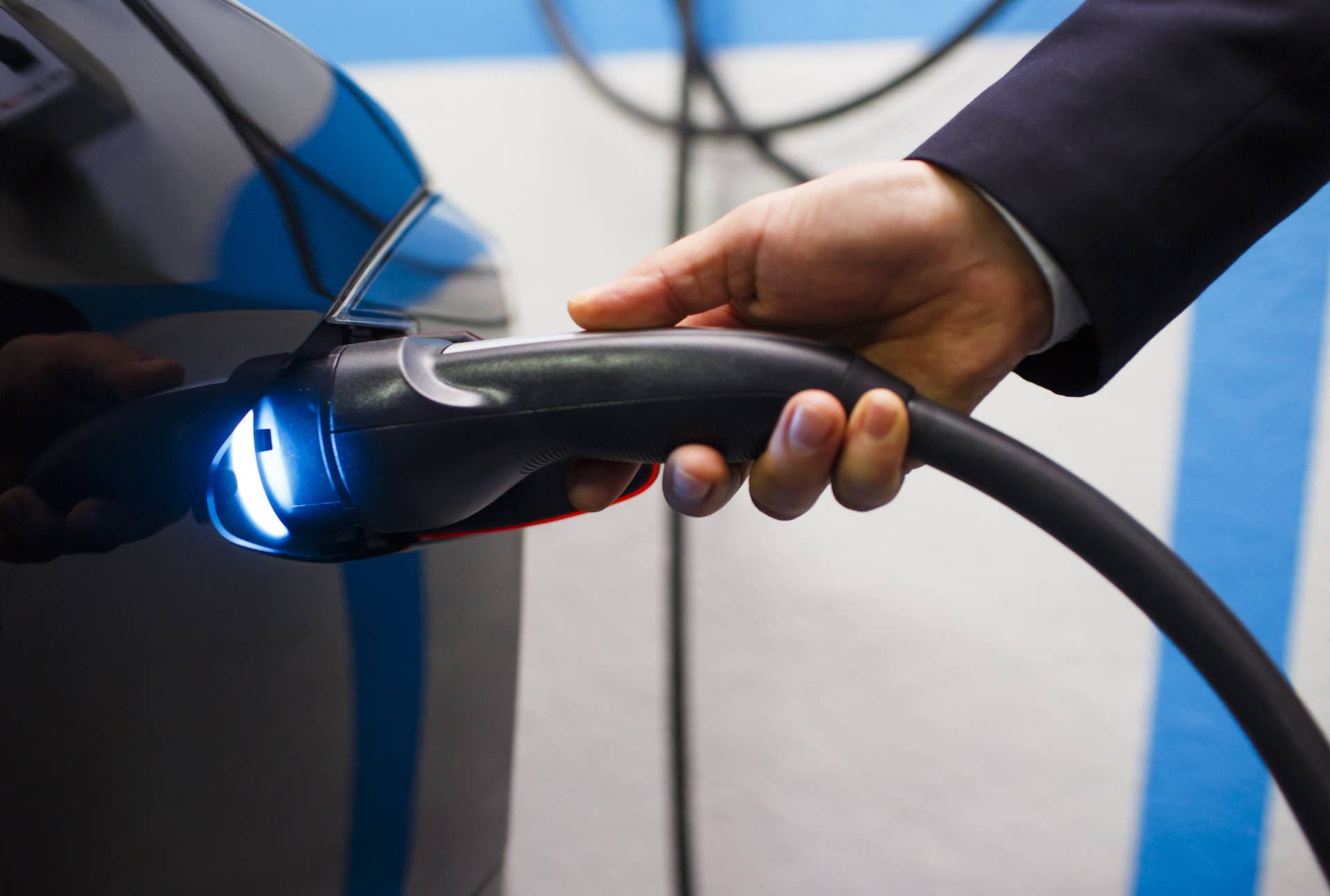An Uber Technologies Inc. driver plugs a charging cable into a Tesla Motors Inc. Model S electric automobile at a charging point at the InterContinental Hotel in Madrid, Spain, on Friday, Jan. 13, 2017. Ride-hailing service Uber Technologies has launched its first electric car taxi service in Madrid, operating a fleet of Tesla Model S electric vehicles. Photographer: Angel Navarrete/Bloomberg via Getty Images