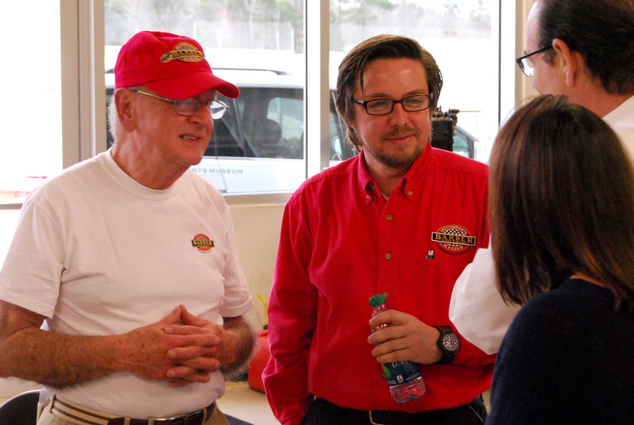 Former racer Robert Kahmer, left, and Barber Vintage Motorsports Museum's lead auto restoration technician John Viviani, center, talk to attendees of the museum's second annual Love of Lotus event. 2/08/14