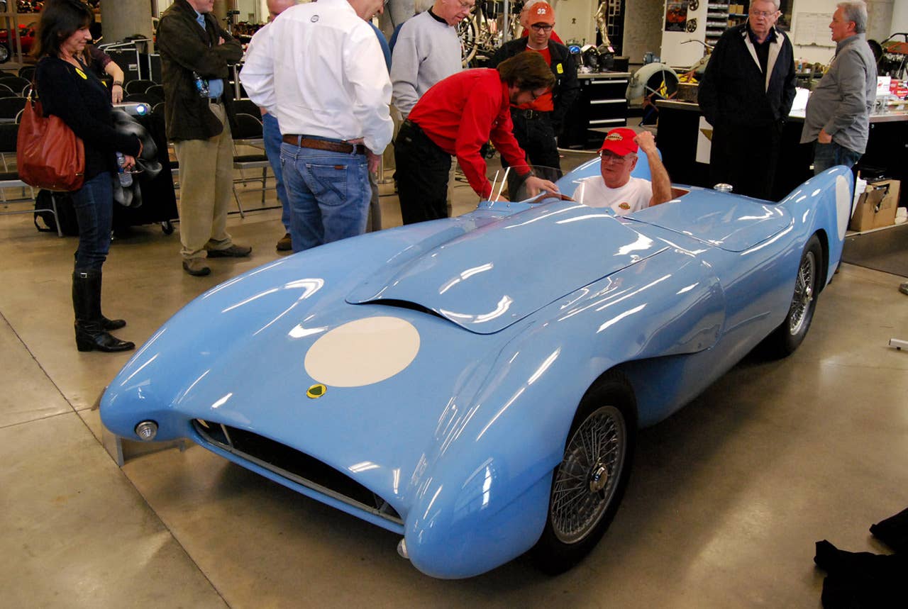 Barber Vintage Motorsports Museum lead auto restoration tech John Viviani, in the red shirt, helps Robert Kahmer climb back into his 1955 Lotus Mark X after 55 years.