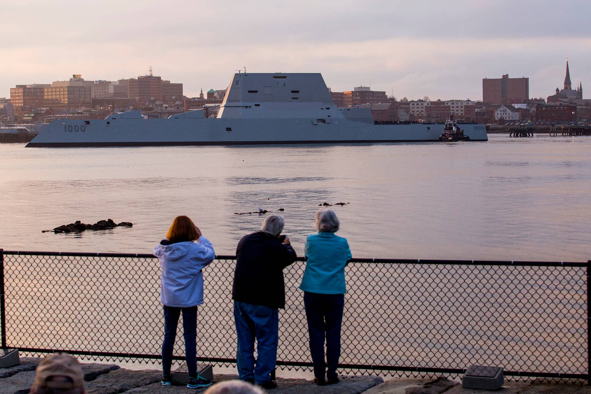 SOUTH PORTLAND, ME - DECEMBER 10: Bystanders look on as the USS Zumwalt, a guided missile destroyer, makes its way through Portland Harbor and is guided into Ocean Gateway Terminal in Portland Thursday, December 10, 2015. (Photo by Gabe Souza/Portland Press Herald via Getty Images)