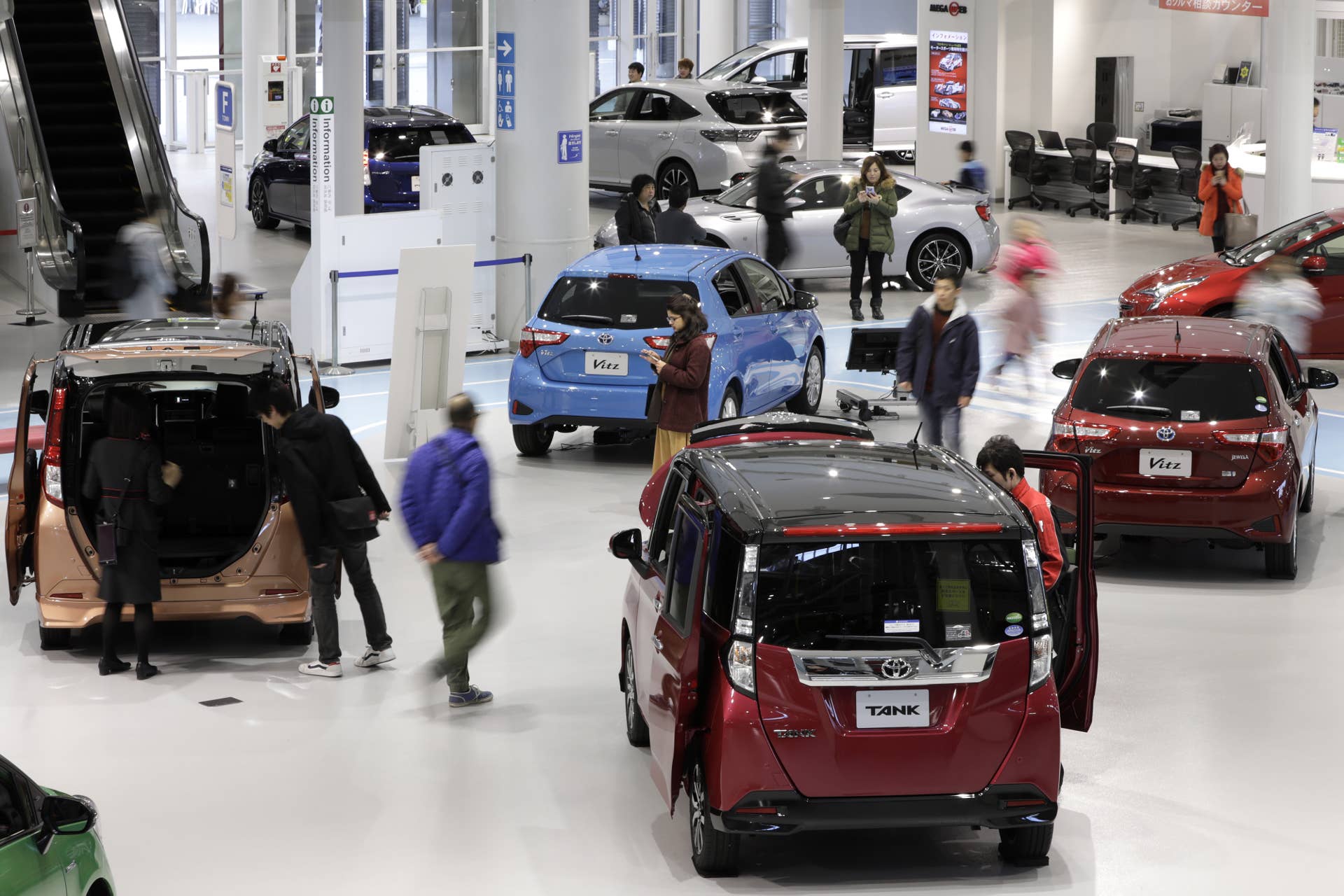 Visitors walk past Toyota Motor Corp. vehicles on display inside the Toyota City Showcase exhibit at the company's Mega Web car theme park in Tokyo, Japan, on Friday, Feb. 3, 2017. Toyota is scheduled to report third-quarter earnings figures on Feb. 6. Photographer: Kiyoshi Ota/Bloomberg via Getty Images