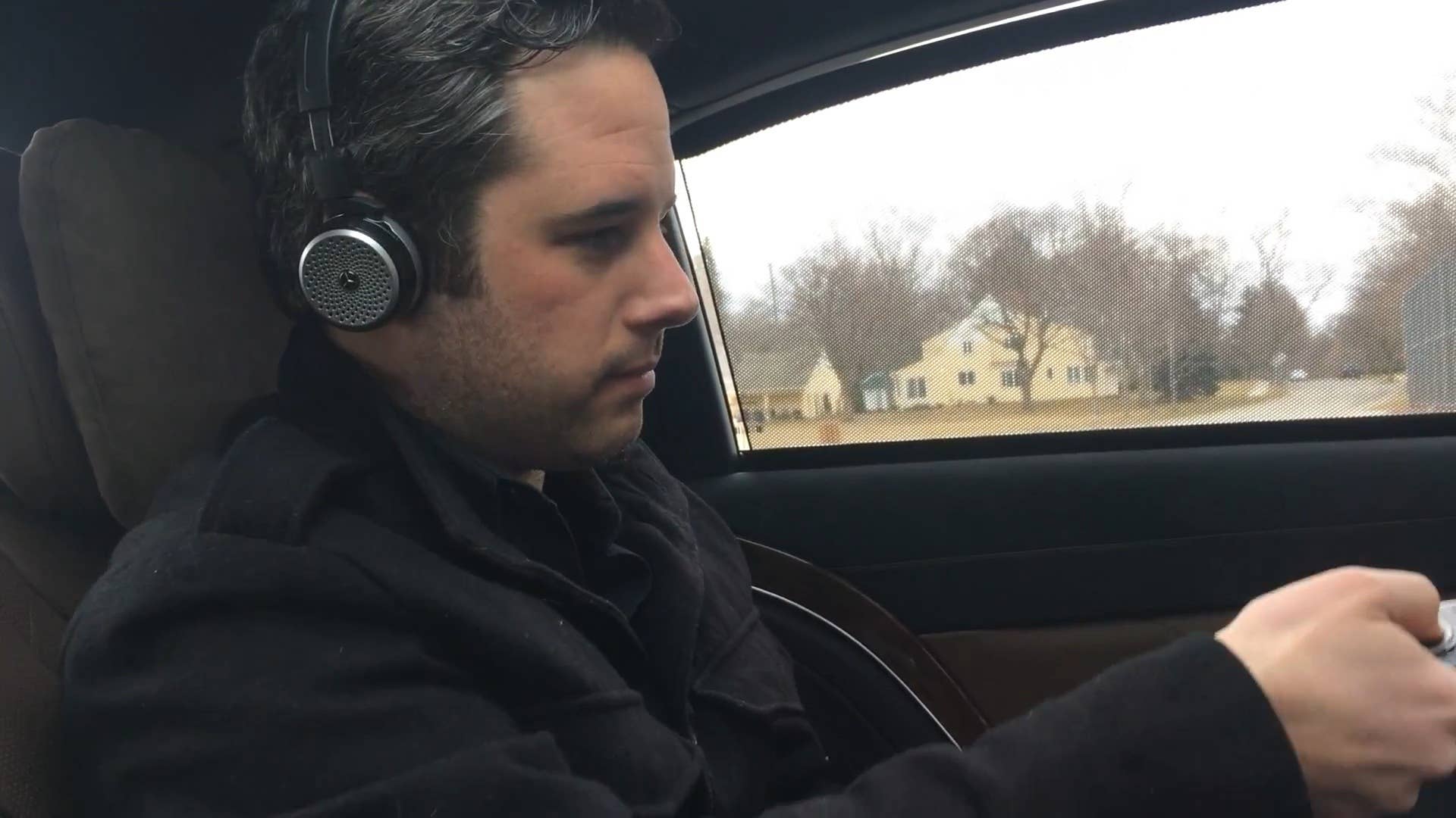 Autoblog's Greg Migliore tries on a pair of Mercedes-branded AKG headphones in the back of the 2016 Mercedes-Maybach S600.