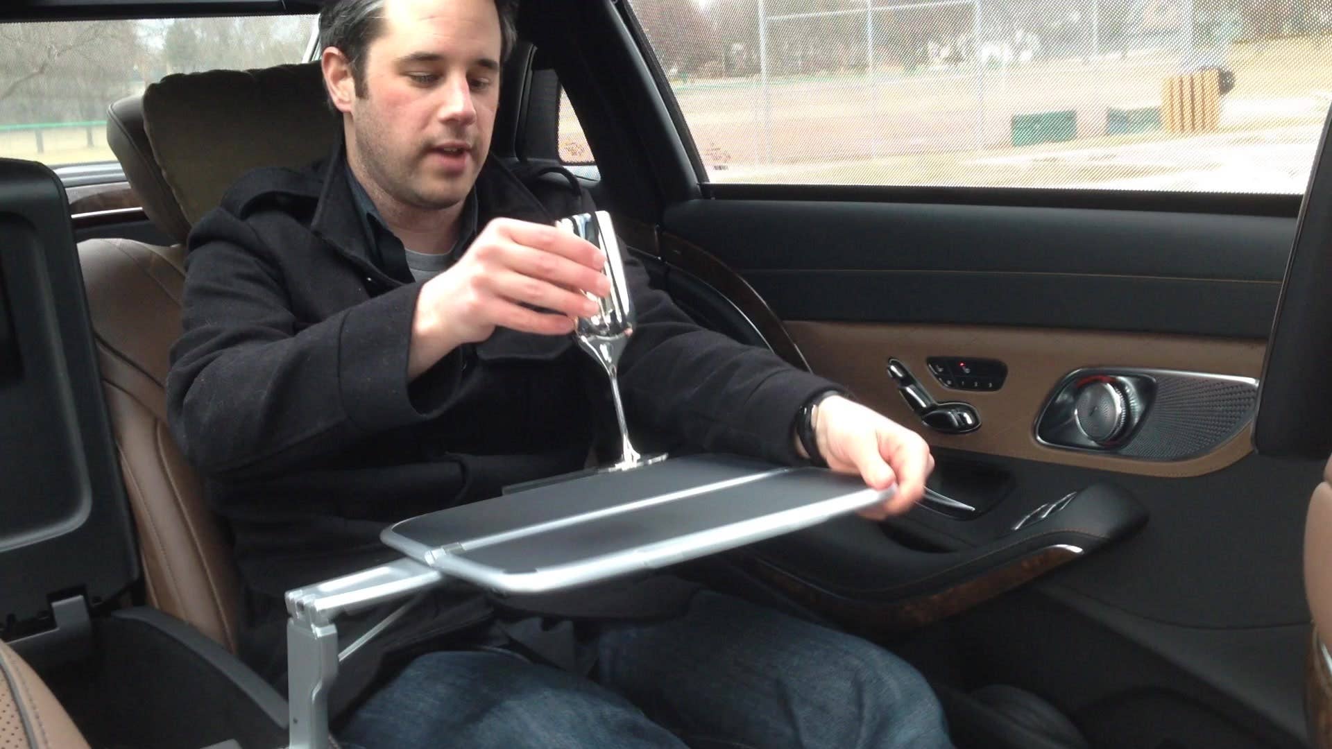 Senior editor Greg Migliore opens up the tray table in the back of the 2016 Mercedes-Maybach S600.