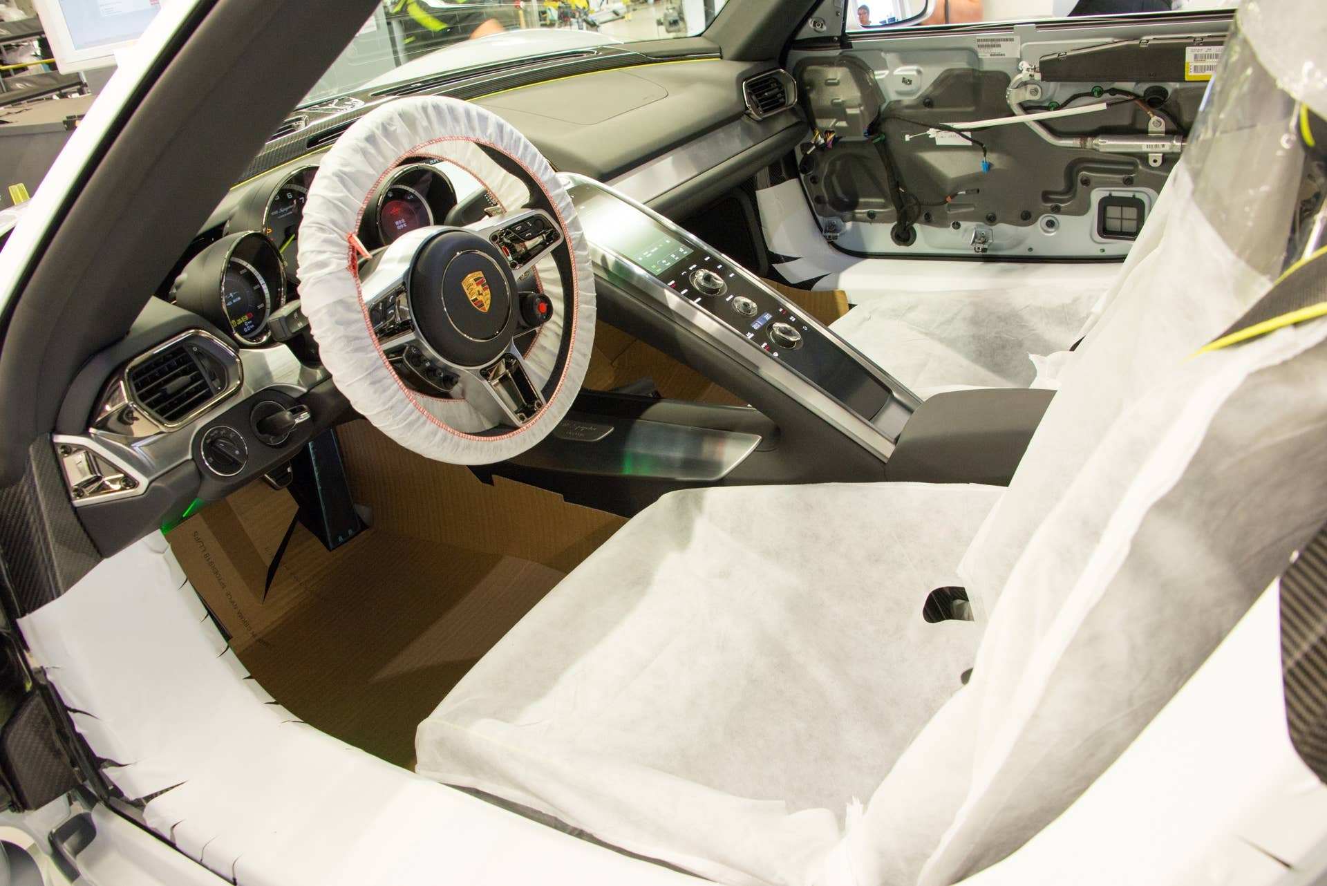 The vehicle's electrical system has been powered at this late stage of assembly, so many of the components may be tested (one 918's stereo was playing "Don't You Want Me," from the Human League — how appropriate).  Protective covers and cardboard protect the delicate surfaces from being accidentally damaged or marred during assembly.