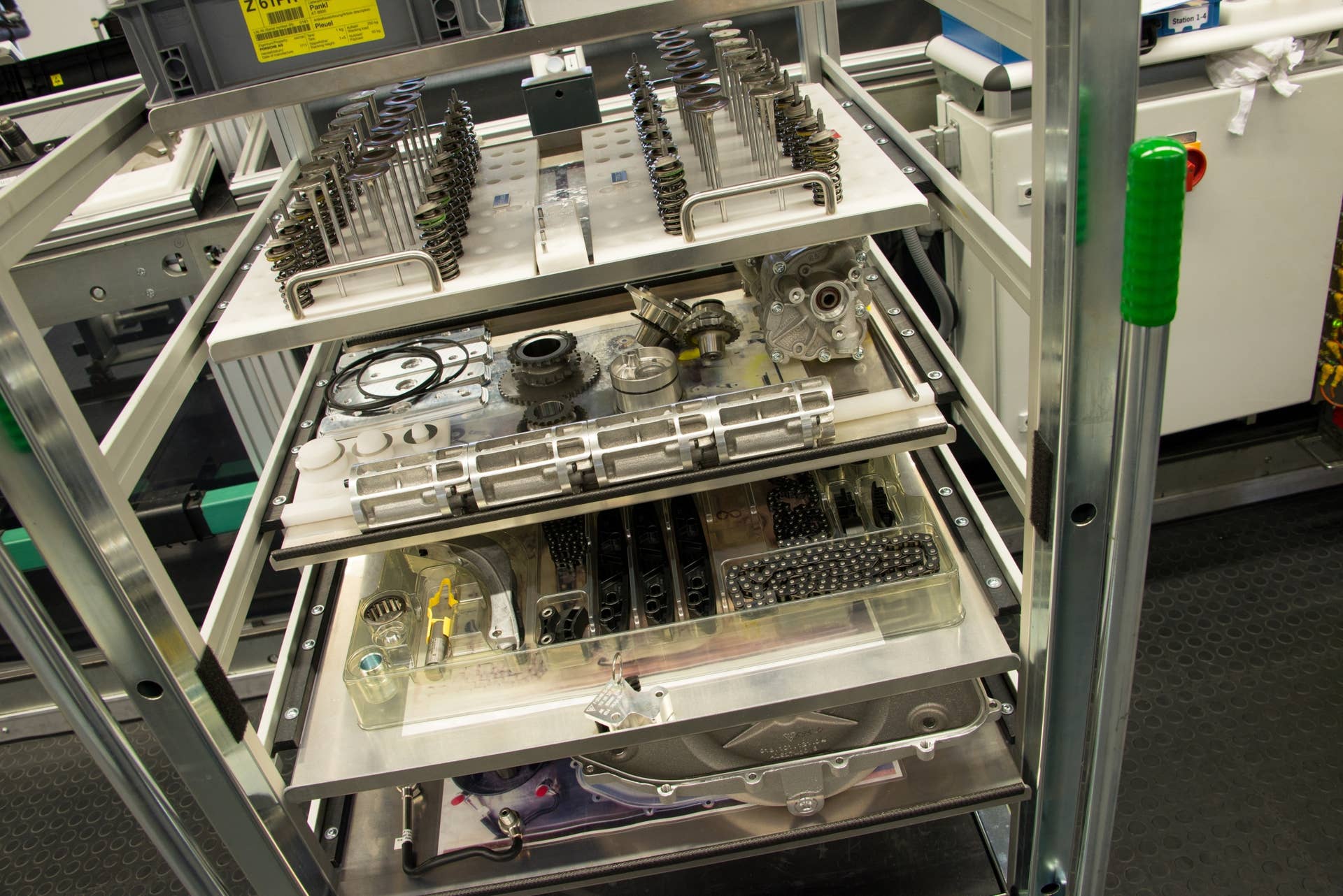Mimicking an operating room, all of the tools and components needed to assemble the 4.6-liter V8 arrive neatly organized on a tray. Most of the valvetrain is visible in this picture, with valves, springs, cam gear, chains and guides all easily identified.