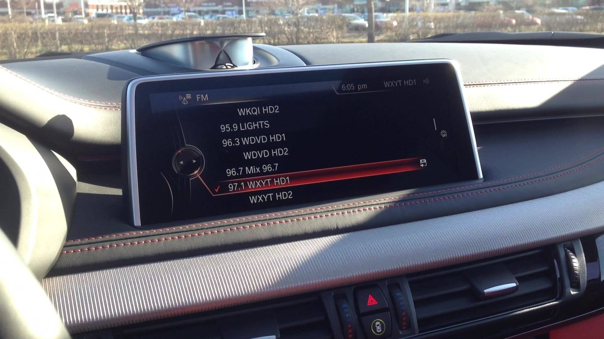 Senior editor Greg Migliore shows off the sporty red interior of the 2016 BMW X5 M.