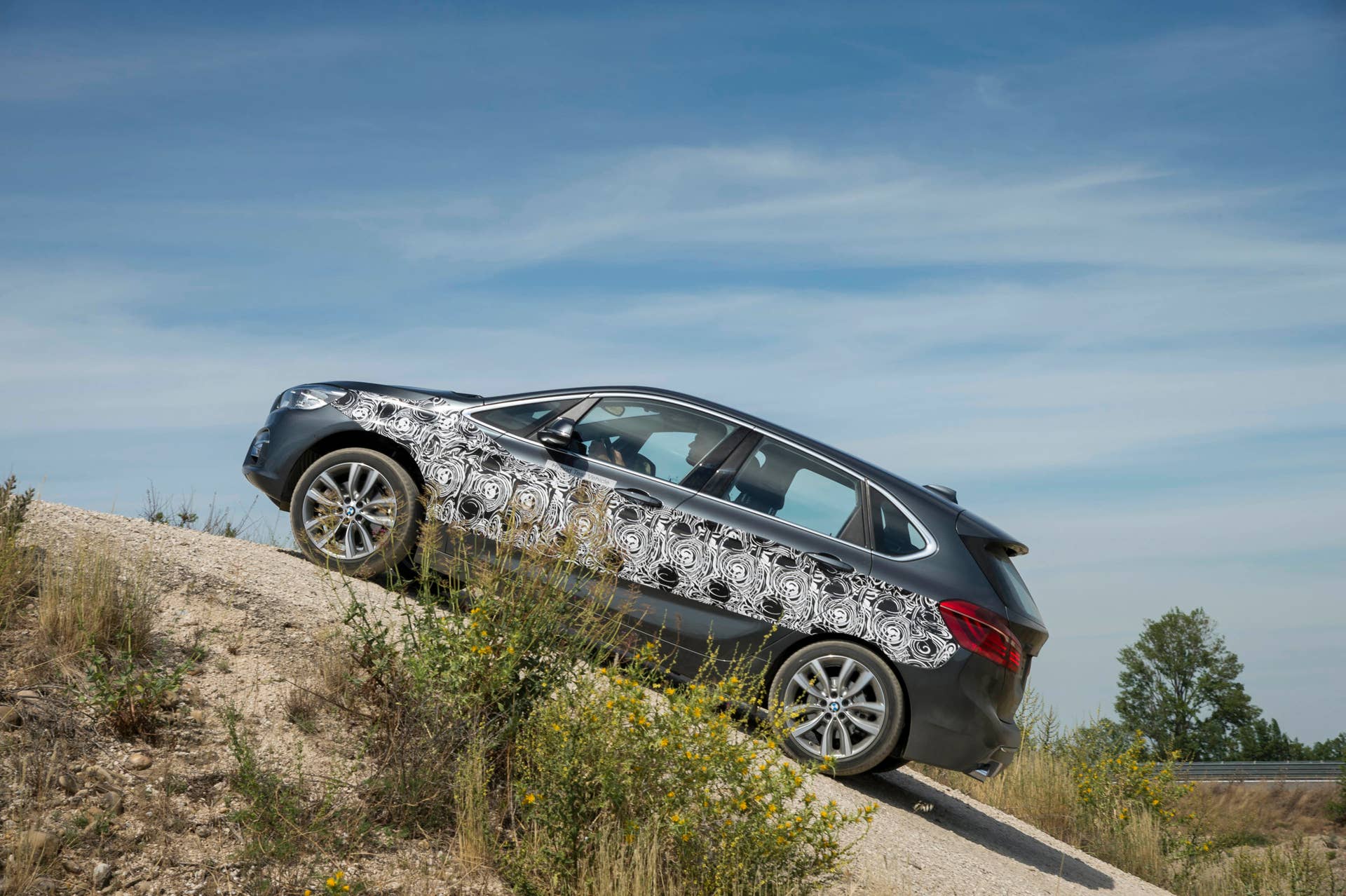 gray bmw 2 series active tourer plug-in hybrid prototype over hill