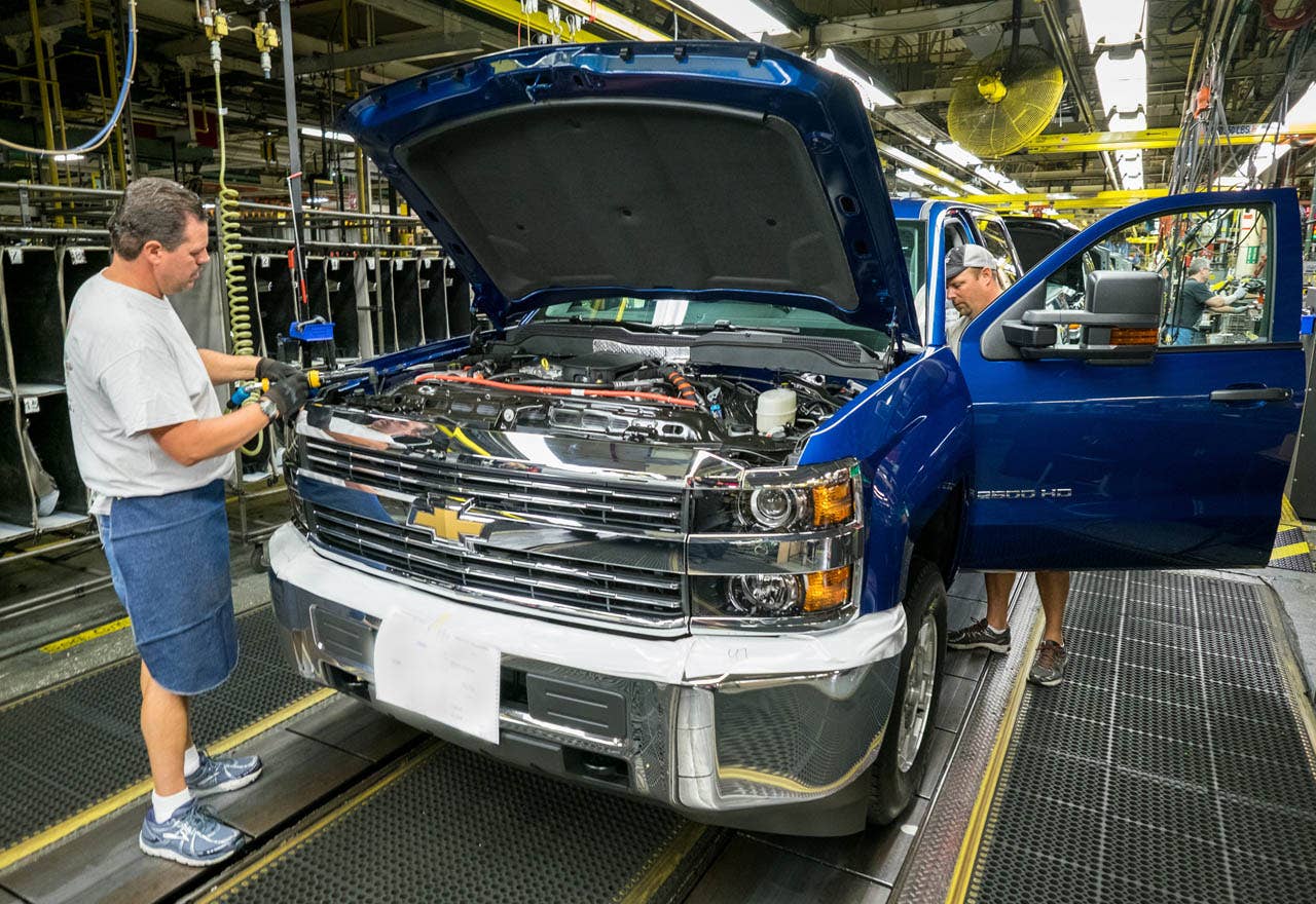 General Motors Flint Assembly employees Al Havens (left) and Dan Hippensteel work on a Chevrolet Silverado 2500 HD truck during final assembly Tuesday, August 4, 2015 in Flint, Michigan. GM announced today that it plans to invest $877 million to build a new body shop for the assembly plant, locating it closer to the Flint Metal Center, which supplies sheet metal and other parts used in the Chevrolet and GMC full-size pickups produced in the assembly plant. (Photo by Steve Fecht for General Motors)