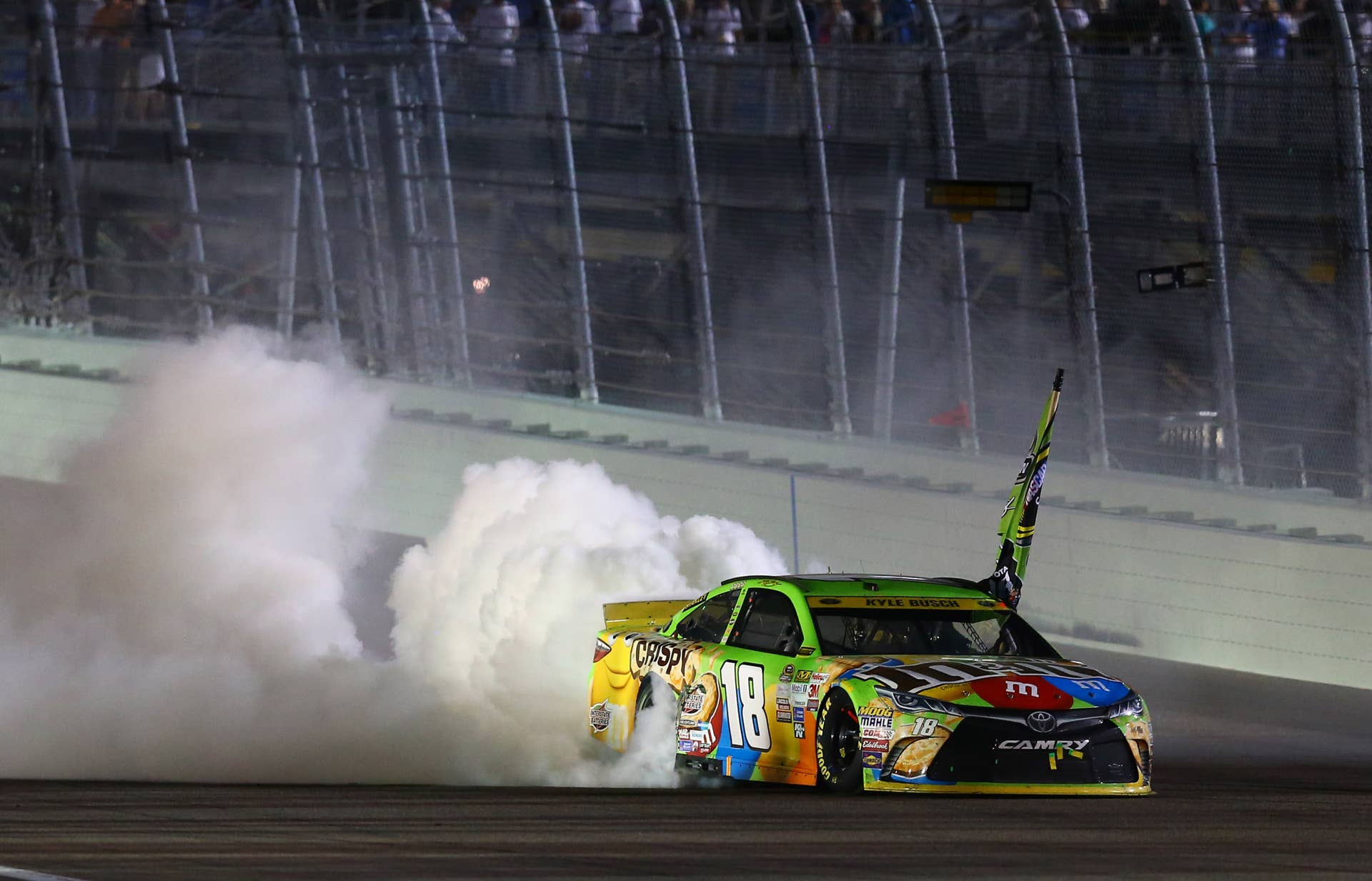 Nov 22, 2015; Homestead, FL, USA; NASCAR Sprint Cup Series driver Kyle Busch celebrates with a burnout after winning the Ford EcoBoost 400 to win the Sprint Cup championship at Homestead-Miami Speedway. Mandatory Credit: Mark J. Rebilas-USA TODAY Sports