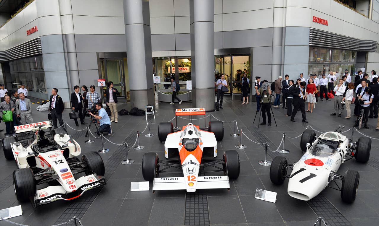 The three-generation Honda Formula One cars, 2006 Honda RA106 (L), 1988 McLaren Honda MP4/4 (C) and 1965 Honda RA272 (R), are on display in front of Honda headquarters after the press conference in Tokyo on May 16, 2013. Japanese automaker Honda said it will return to Formula One in 2015 as an engine supplier to British team McLaren in a bid to revive their championship-winning partnership.          AFP PHOTO / TOSHIFUMI KITAMURATOSHIFUMI KITAMURA/AFP/Getty Images