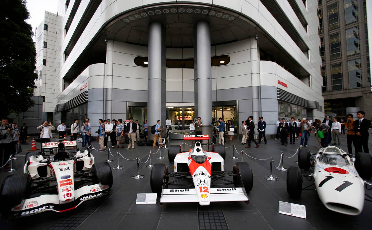 Honda's past Fomula One cars are displayed in front of the Honda Motor Co. headquarters in Tokyo after its President Takanobu Ito held a press conference Thursday, May 16, 2013. Ito announced that Japanese automaker Honda is returning to Formula One in 2015 as an engine supplier to McLaren, recreating a partnership that was dominant in the 1980s and 1990s. Ito reversed the decision made in 2008 to pull out of the expensive sport due to the effects of the global financial crisis. The cars, are from left, Honda RA106 driven by Britain's Jenson Button, McLaren Honda MP 4/4 by the late Brazilian driver Ayrton Senna and Honda RA272 which won the team's first F1 Grand Prix. (AP Photo/Shizuo Kambayashi)