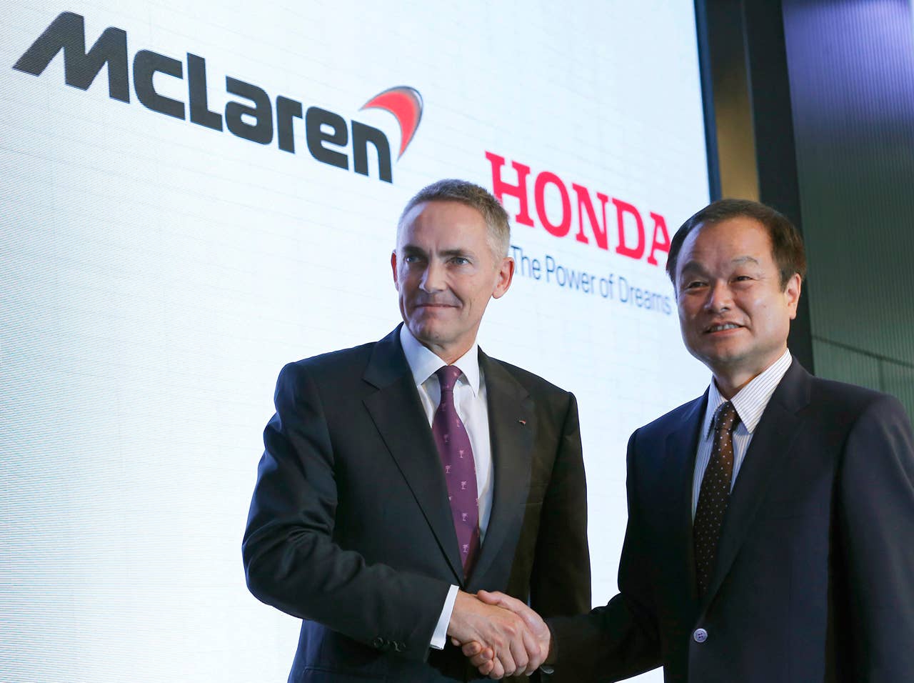 Honda Motor Co. President Takanobu Ito, right, poses with McLaren Group Ltd. CEO Martin Whitmarsh for photographers after their joint press conference in Tokyo, Thursday, May 16, 2013. Japanese automaker Honda is returning to Formula One in 2015 as an engine supplier to McLaren, recreating a partnership that was dominant in the 1980s and 1990s. Ito announced the decision at the press conference, reversing the decision made in 2008 to pull out of the expensive sport due to the effects of the global financial crisis. (AP Photo/Shizuo Kambayashi)